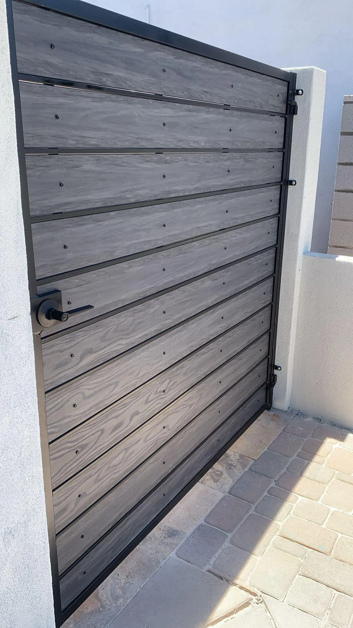 Modern gray wood-and-metal pedestrian gate installed in Phoenix, Arizona