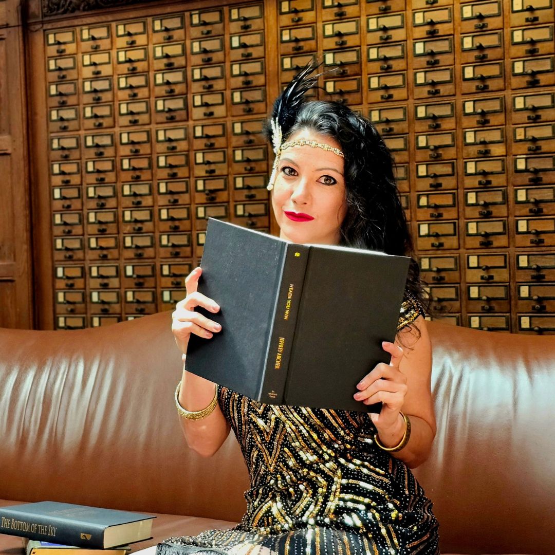 A warm, approachable portrait of Kaye Kennedy, a woman in her 40s with curly hair and expressive eyes, wearing a soft gold blouse. The background is a blurred bookshelf, suggesting wisdom and creativity.