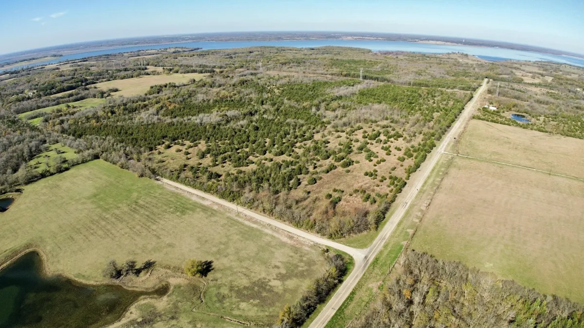 white concrete building near green trees and body of water during daytime