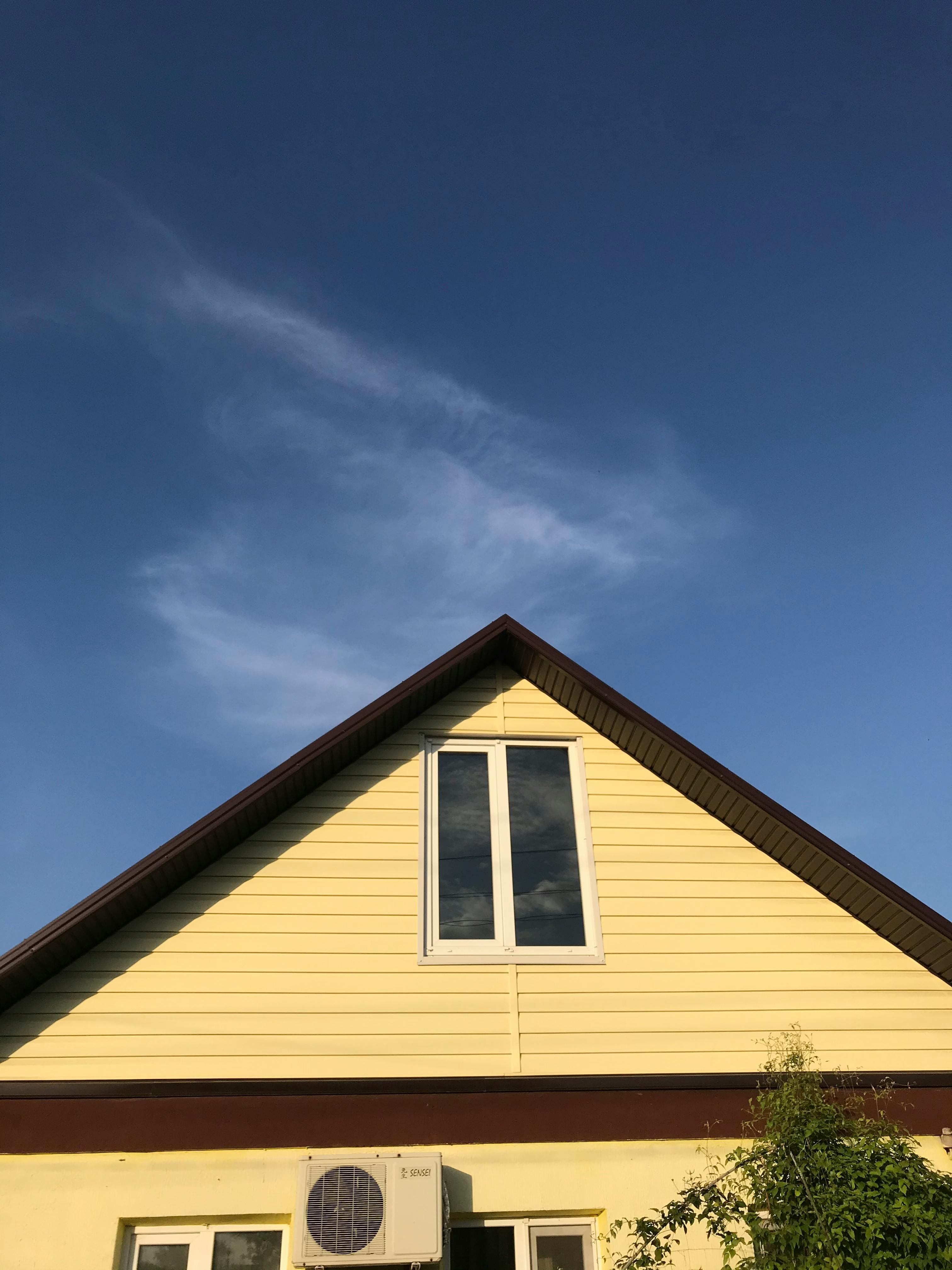 Contractor installing wood siding with flashing around window openings