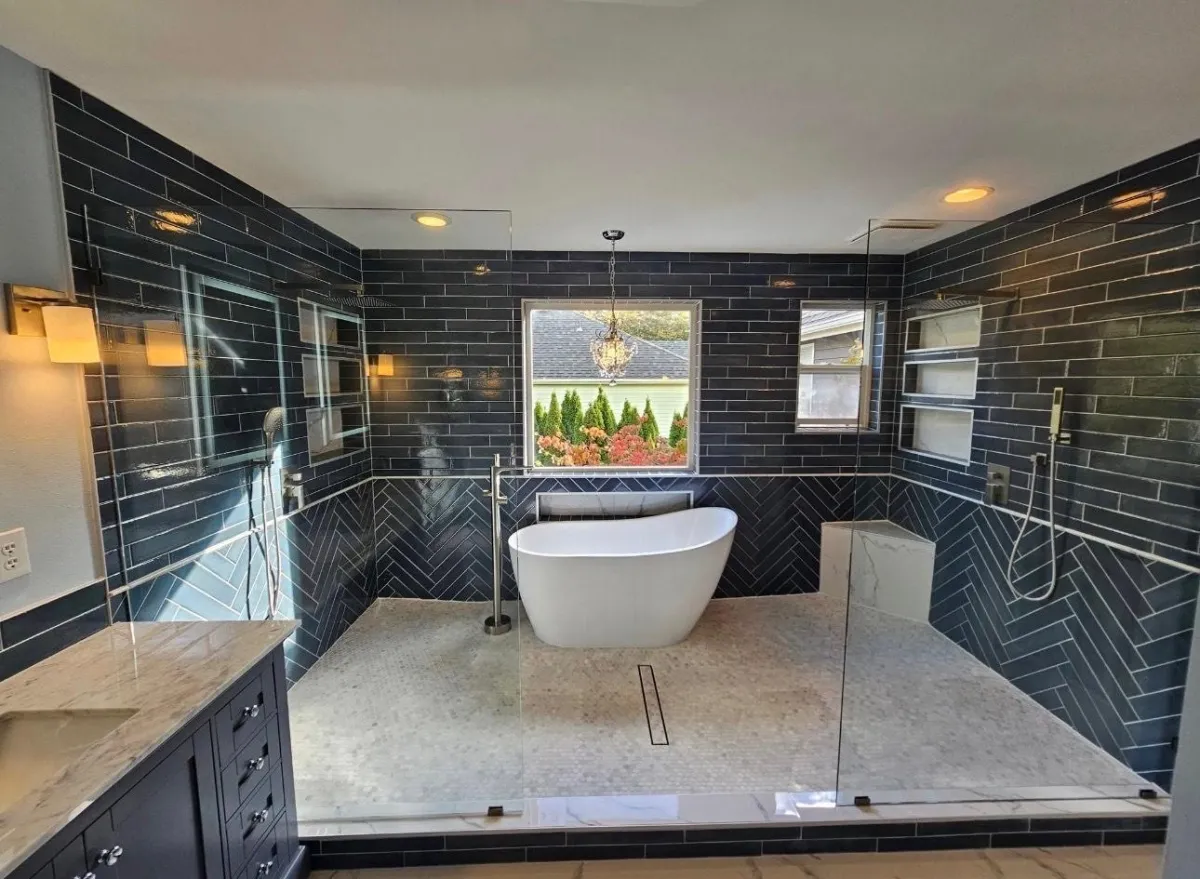 Contemporary bathroom with dark tile shower, glass enclosure, and soaking tub.