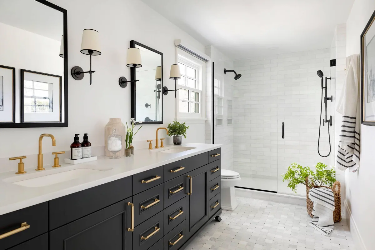 Bathroom with custom black vanity, marble flooring, and gold fixtures.