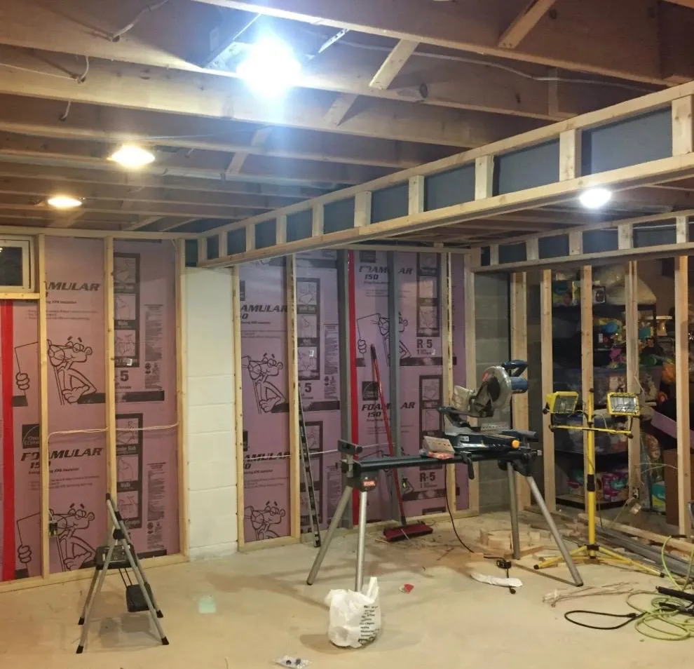 Interior remodel in progress with exposed framing, insulation, and electrical work.