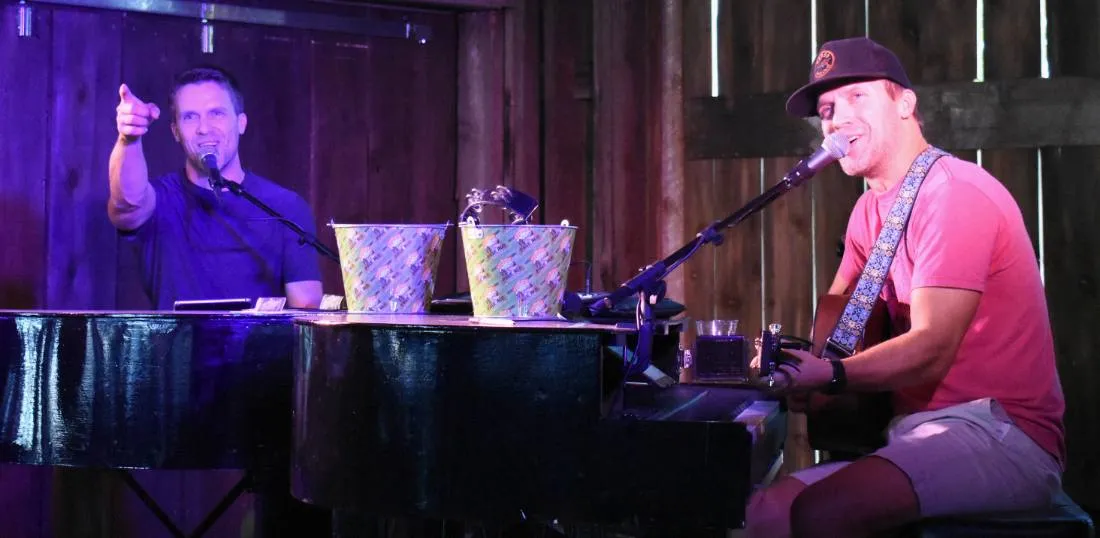 The Kelly Twins performing live, one at the piano and one on guitar
