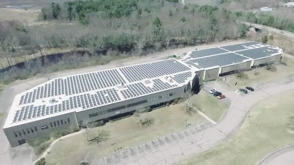 an aerial view of a house with a solar panel on the roof