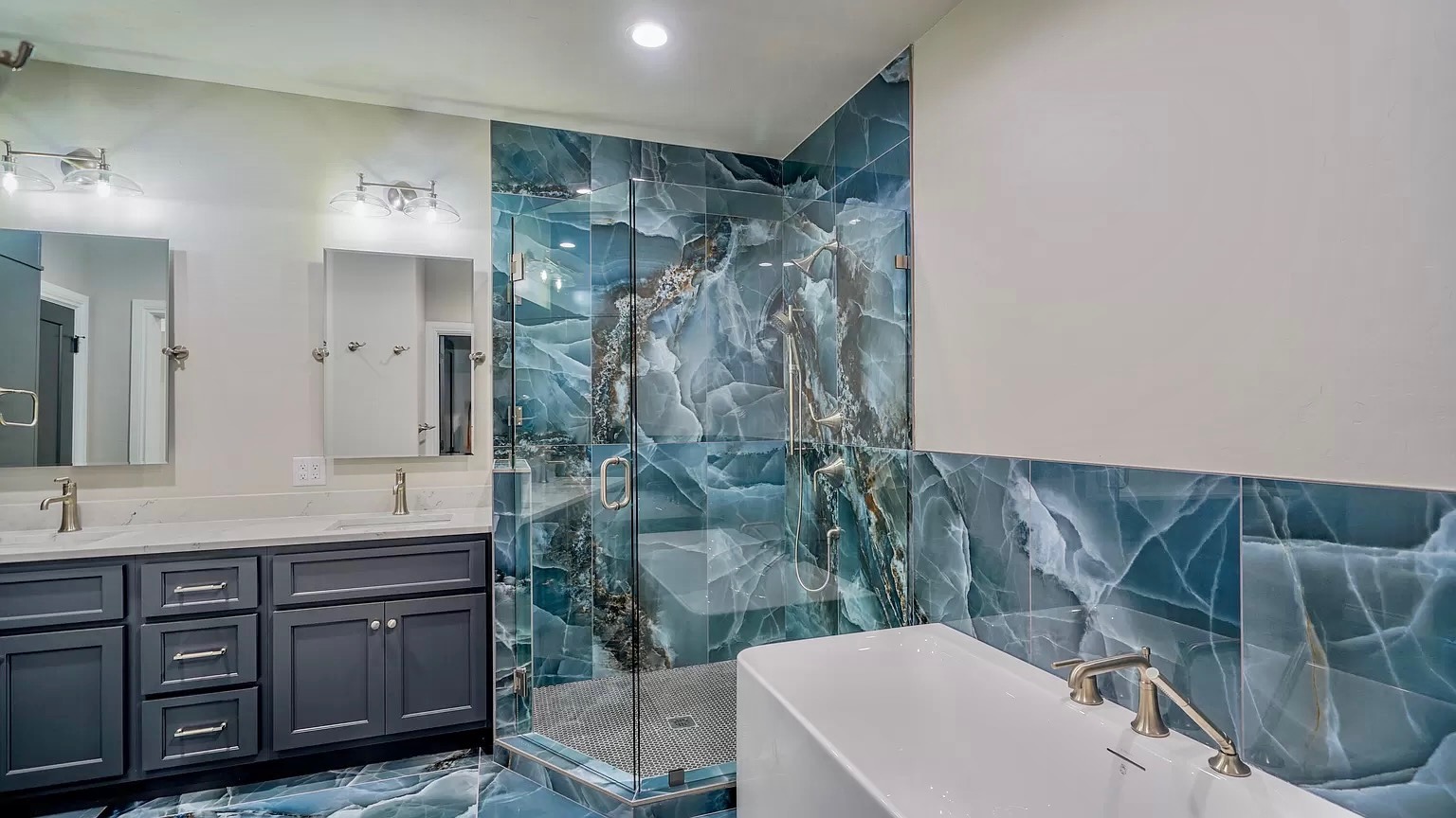Bathroom renovation with white double vanity, marble countertop, and gold faucet fixtures