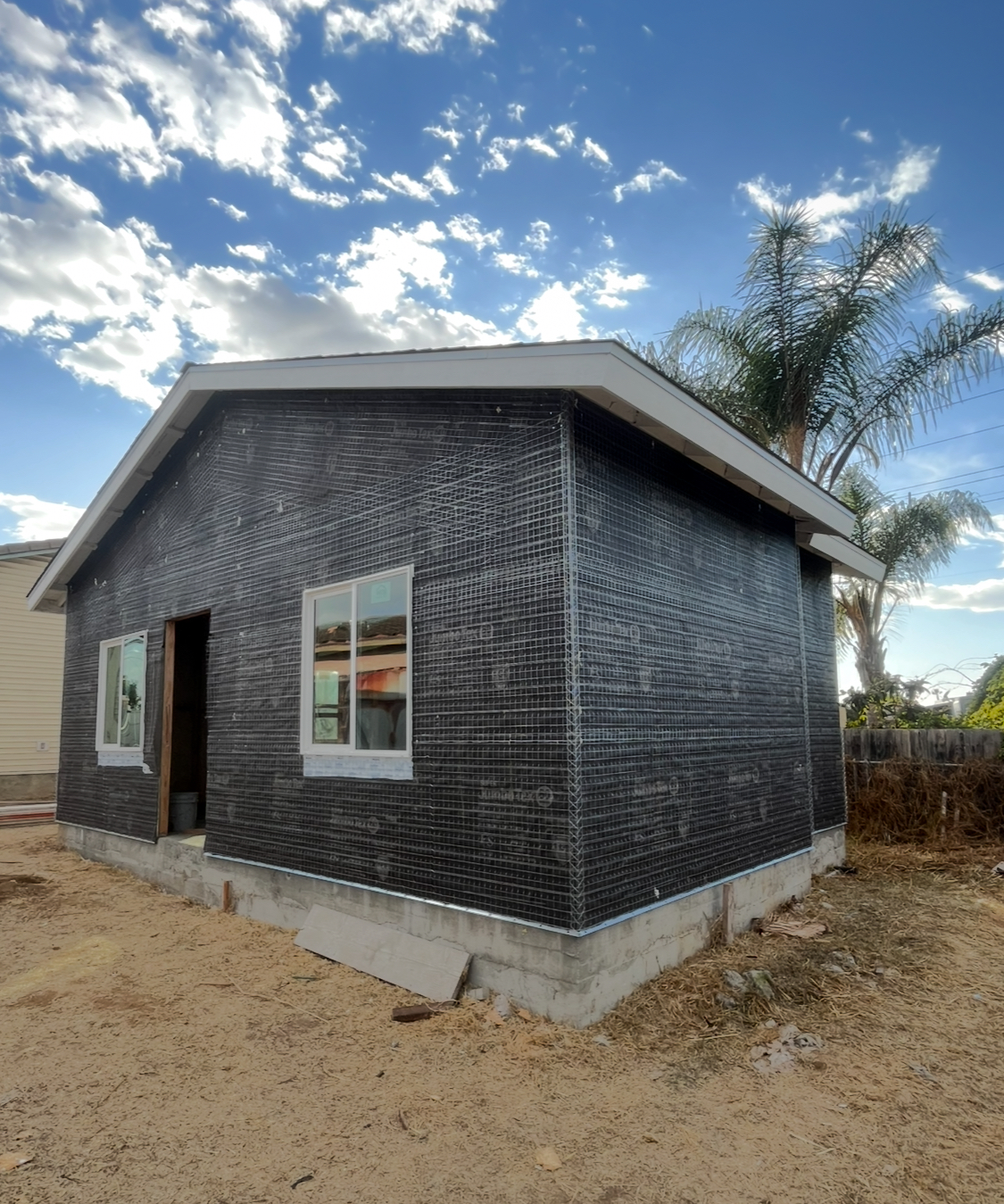 stucco application and restoration on a dark grey house