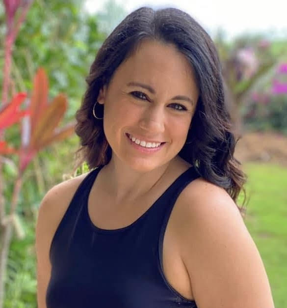Smiling female physical therapist in a green blouse, showcasing a friendly demeanor, representing the Moving and Grooving Pediatric Physical Therapy team.
