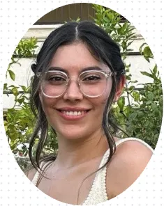 Smiling young woman with glasses, surrounded by greenery, representing the dedicated therapy team at Moving and Grooving Pediatric Physical Therapy.