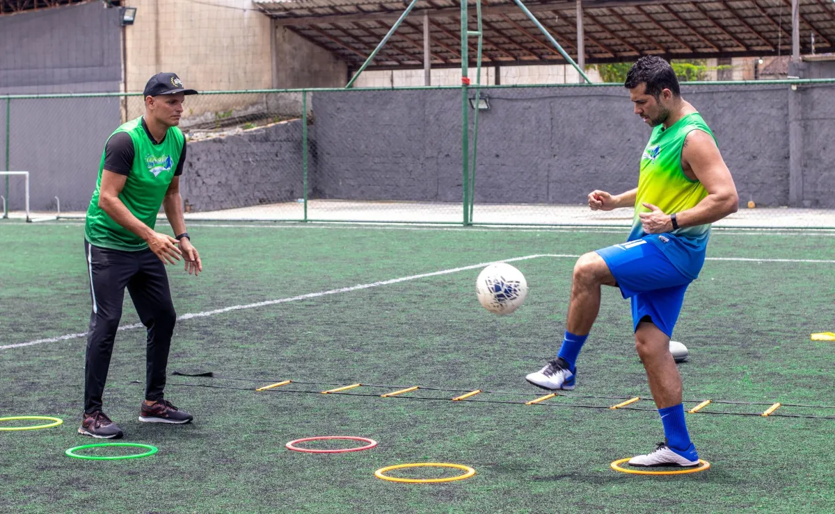 Two men practicing soccer drills