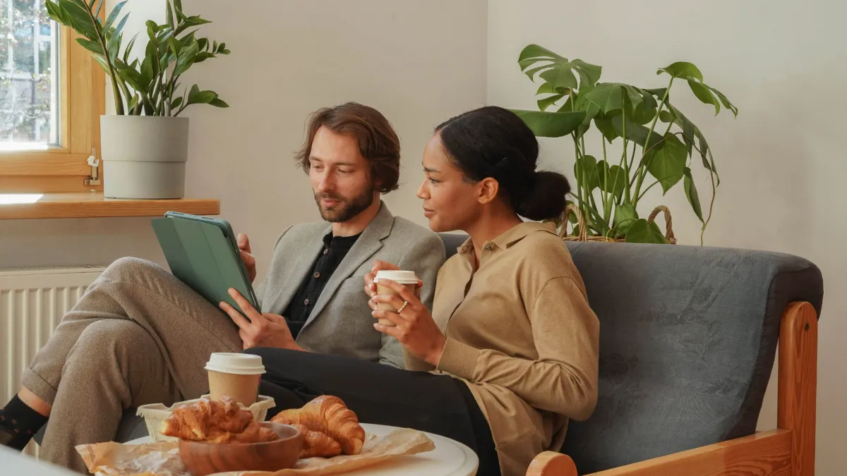 A man in a black suit loosening his tie