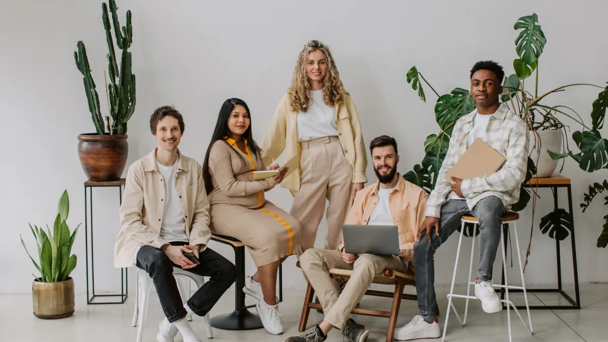 people sitting down near table with assorted laptop computers
