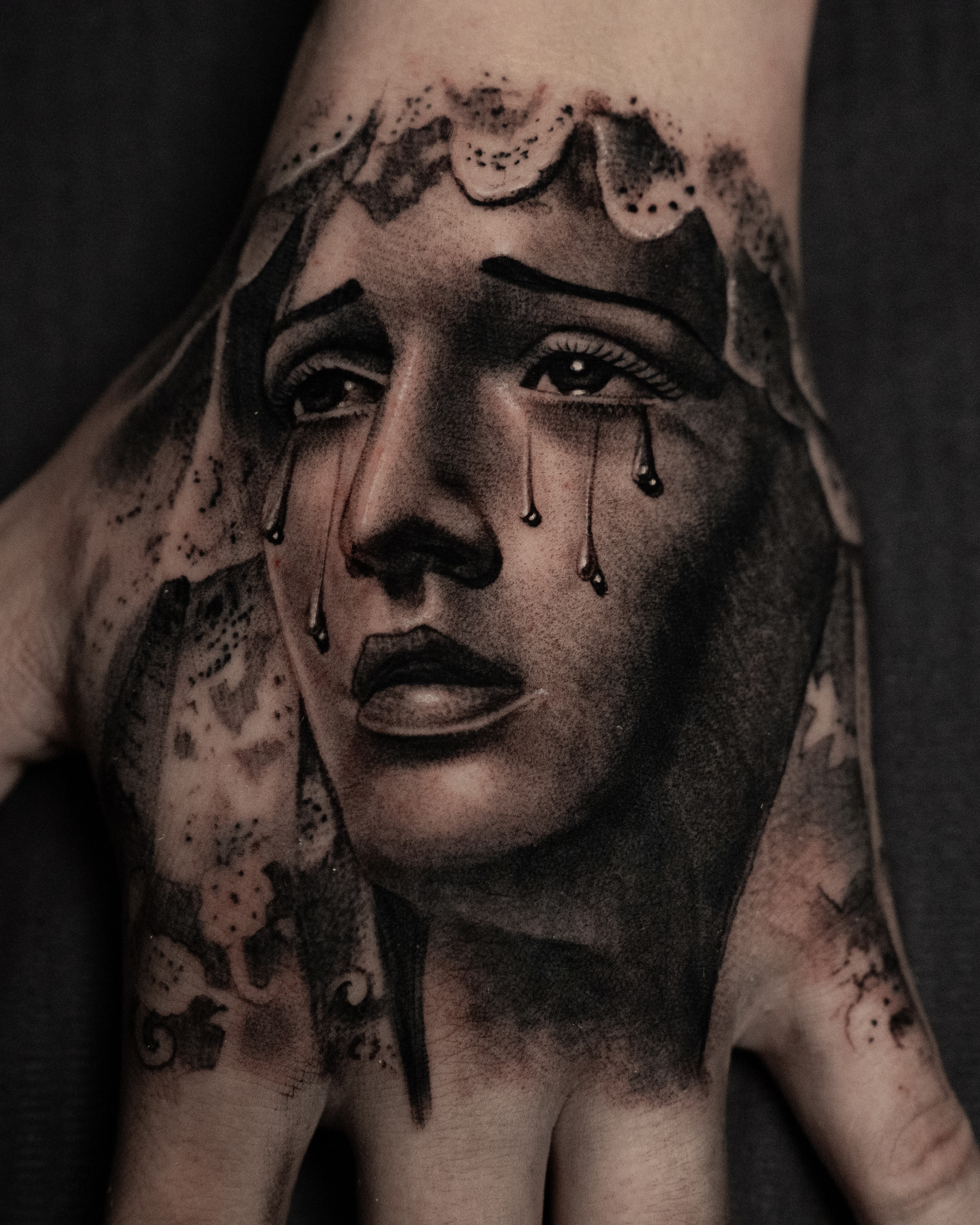 A geometric wolf tattoo in blackwork style, placed on a man’s upper arm. The design features sharp lines, dotwork shading, and abstract shapes forming the wolf’s face. The image is shot in a modern studio with a dark background, highlighting the bold contrast.