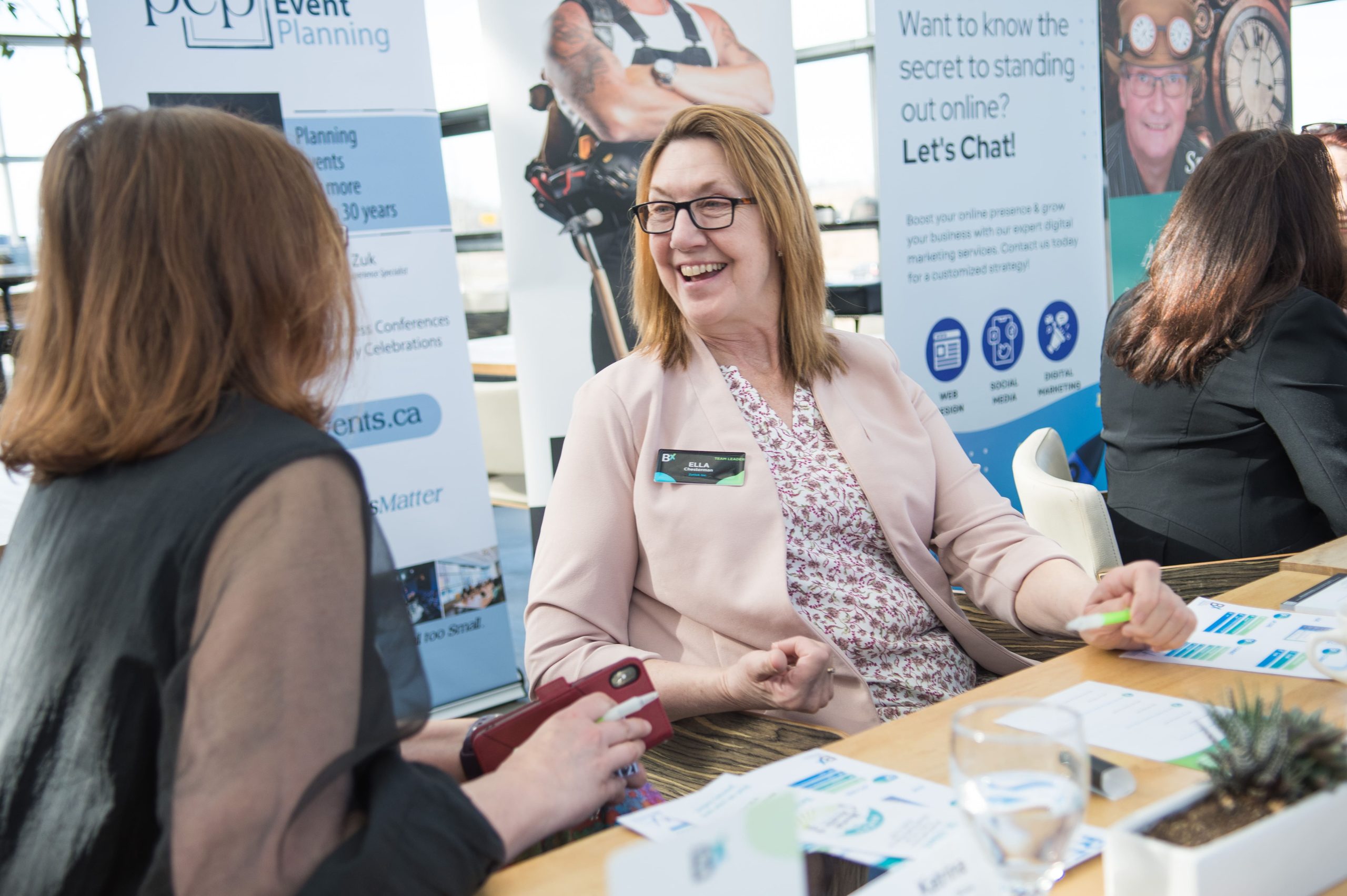 Audience members seated in a conference hall watching a presentation.