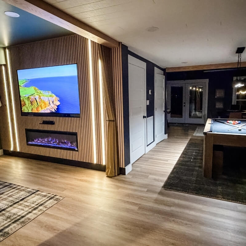 Open basement layout featuring movie room fireplace wall and adjacent game room with pool table