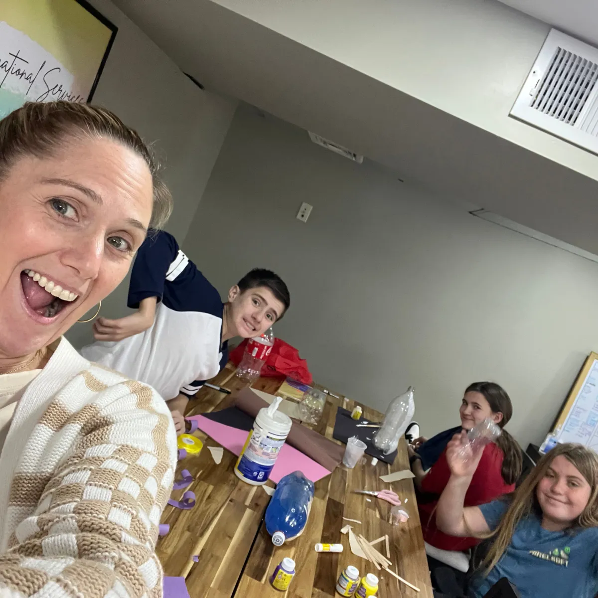 Preteen students smiling with teacher during Friendship Confidence™ Program social group for kids developing confidence and friendship skills.