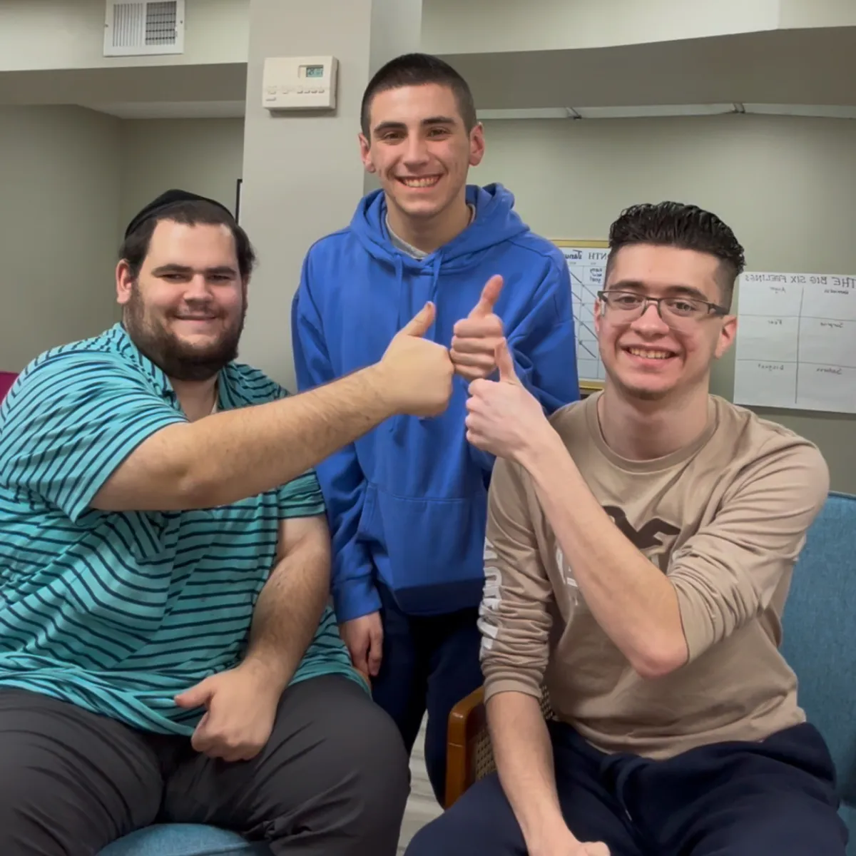 Teen boys smiling and giving thumbs up during the Friendship Confidence™ Program social skills group for teens learning to make friends and build confidence.
