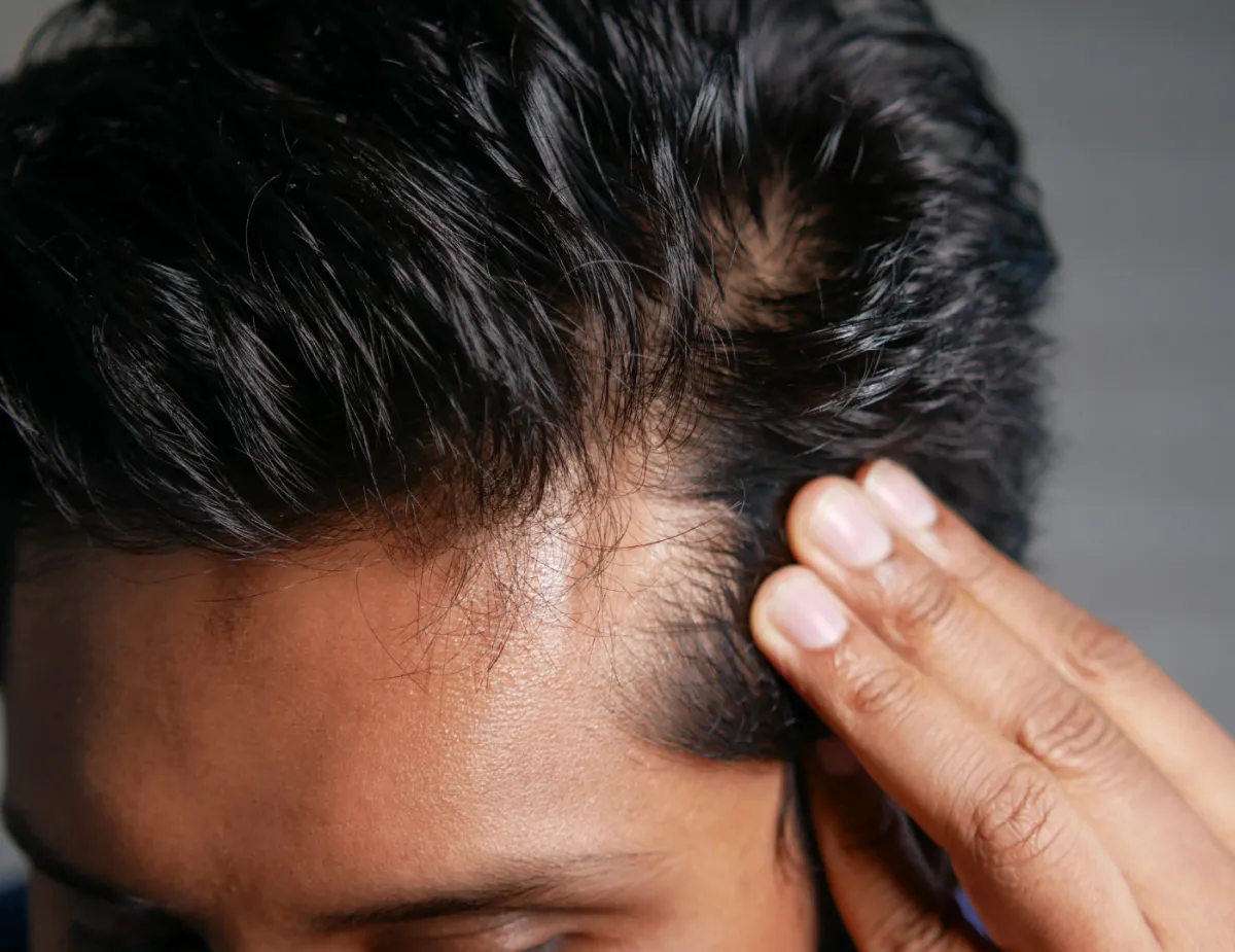 woman cutting the hair of man sitting on barber armchair