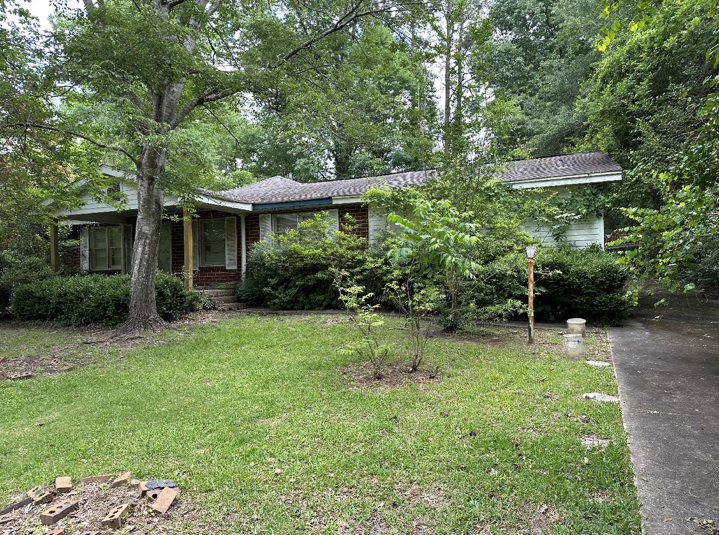 We buy houses cash in Perry GA. House with overgrown yard and roof in bad condition.