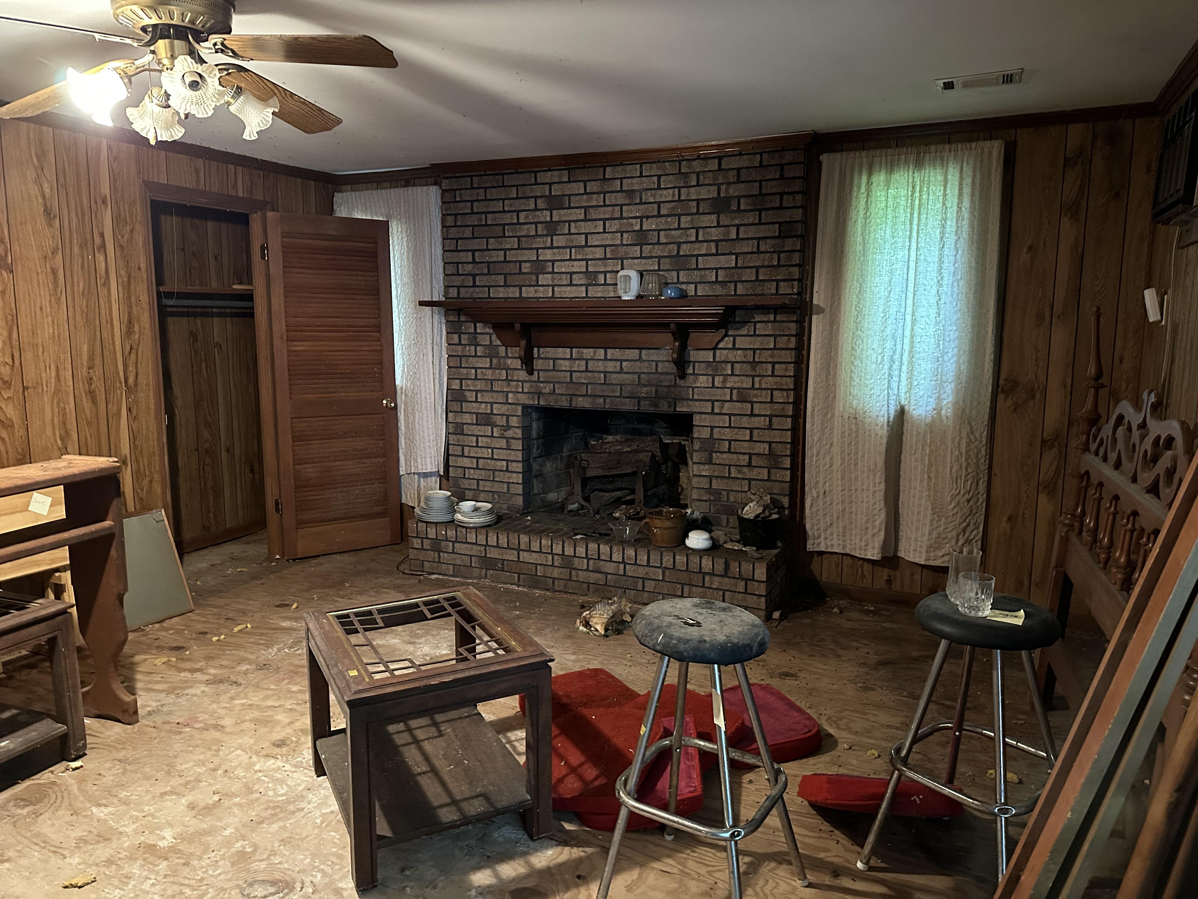 We buy houses fast in Perry GA. Old living room with dirty fireplace and water damage.JPG