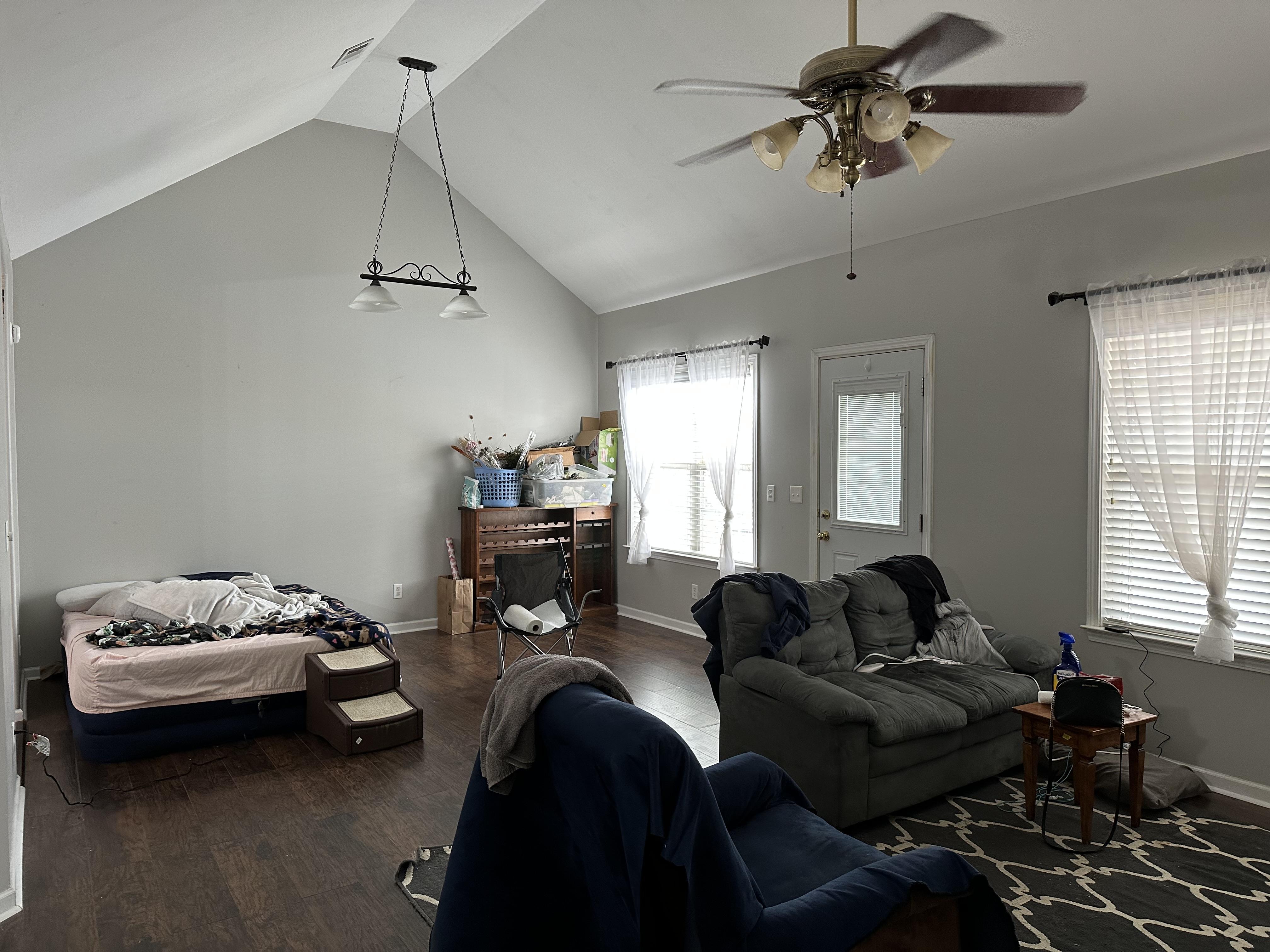 We Buy houses as is in Bonaire GA. Living room with left behind furniture and scratched hardwoods.JPG