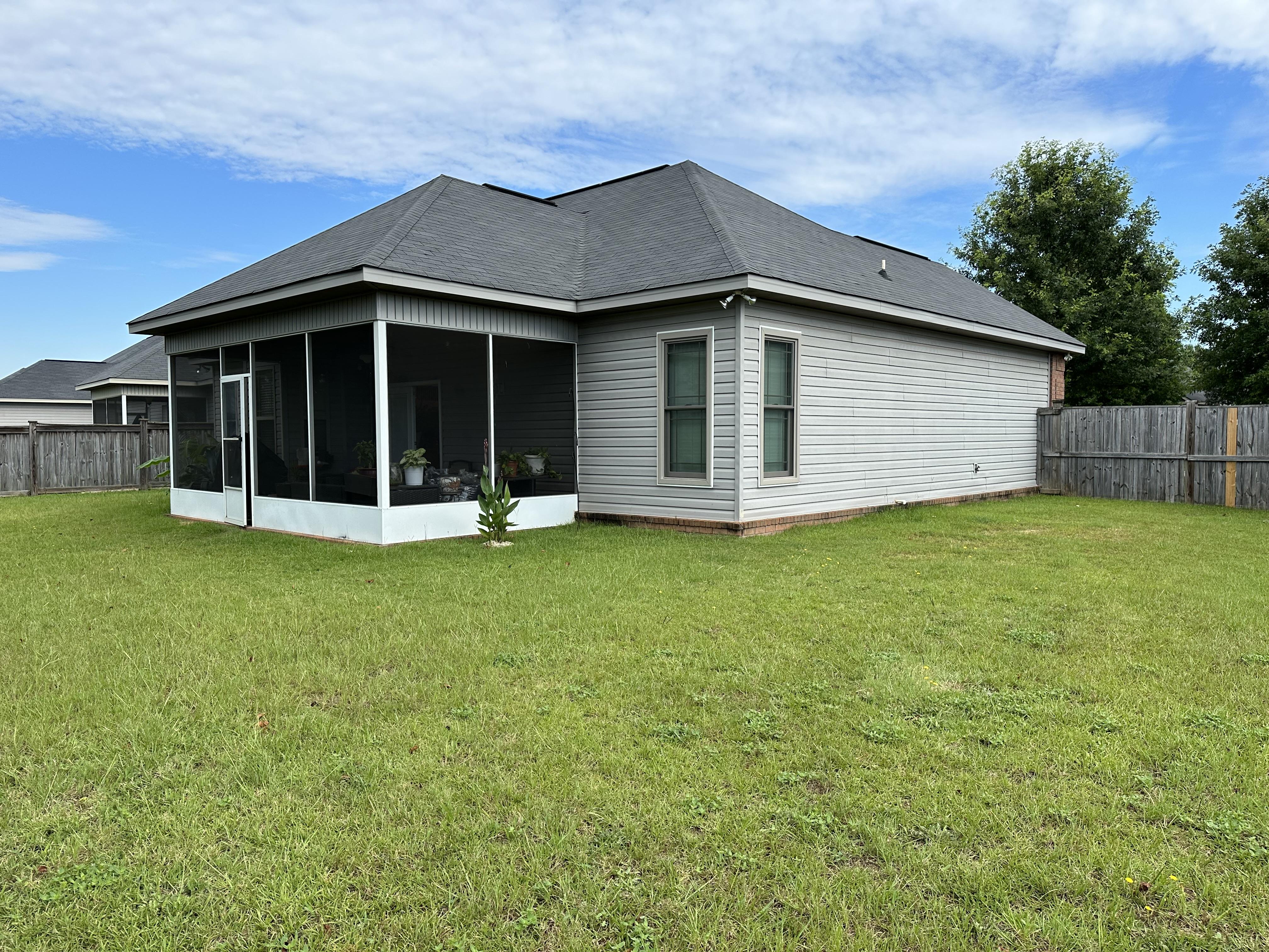 We buy houses as is in Byron GA. Back of house that needs a new roof, gutters, siding and fence.JPG