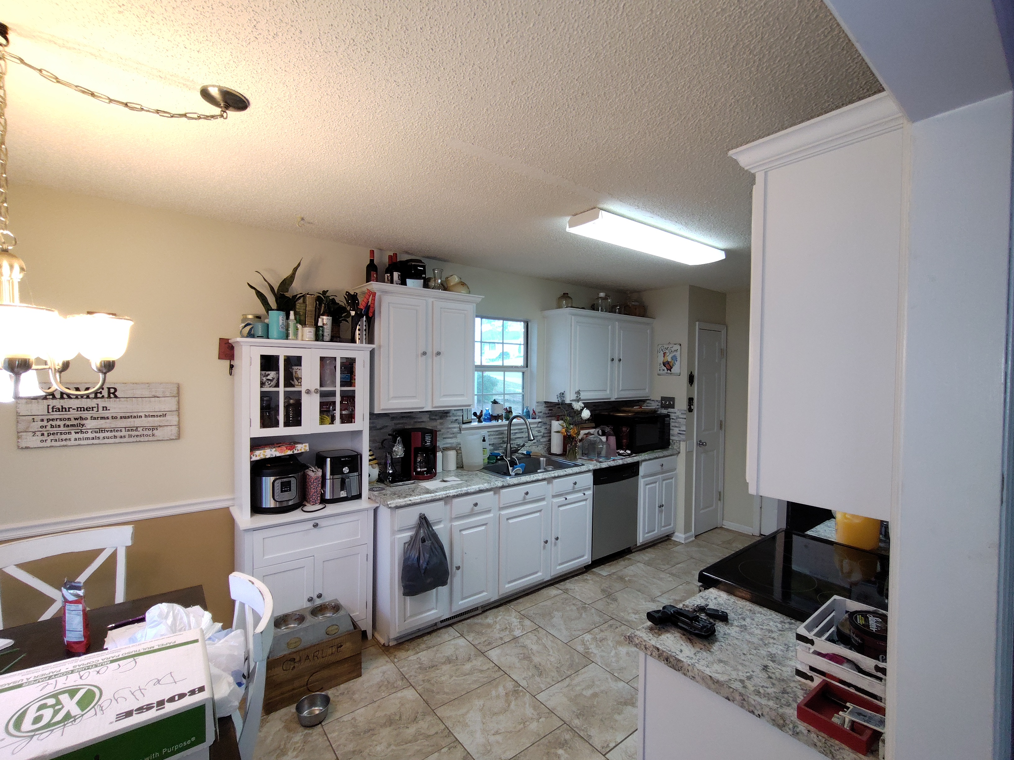 Sell my house fast in Byron GA. Cluttered kitchen with vinyl flooring and needs updates.jpg