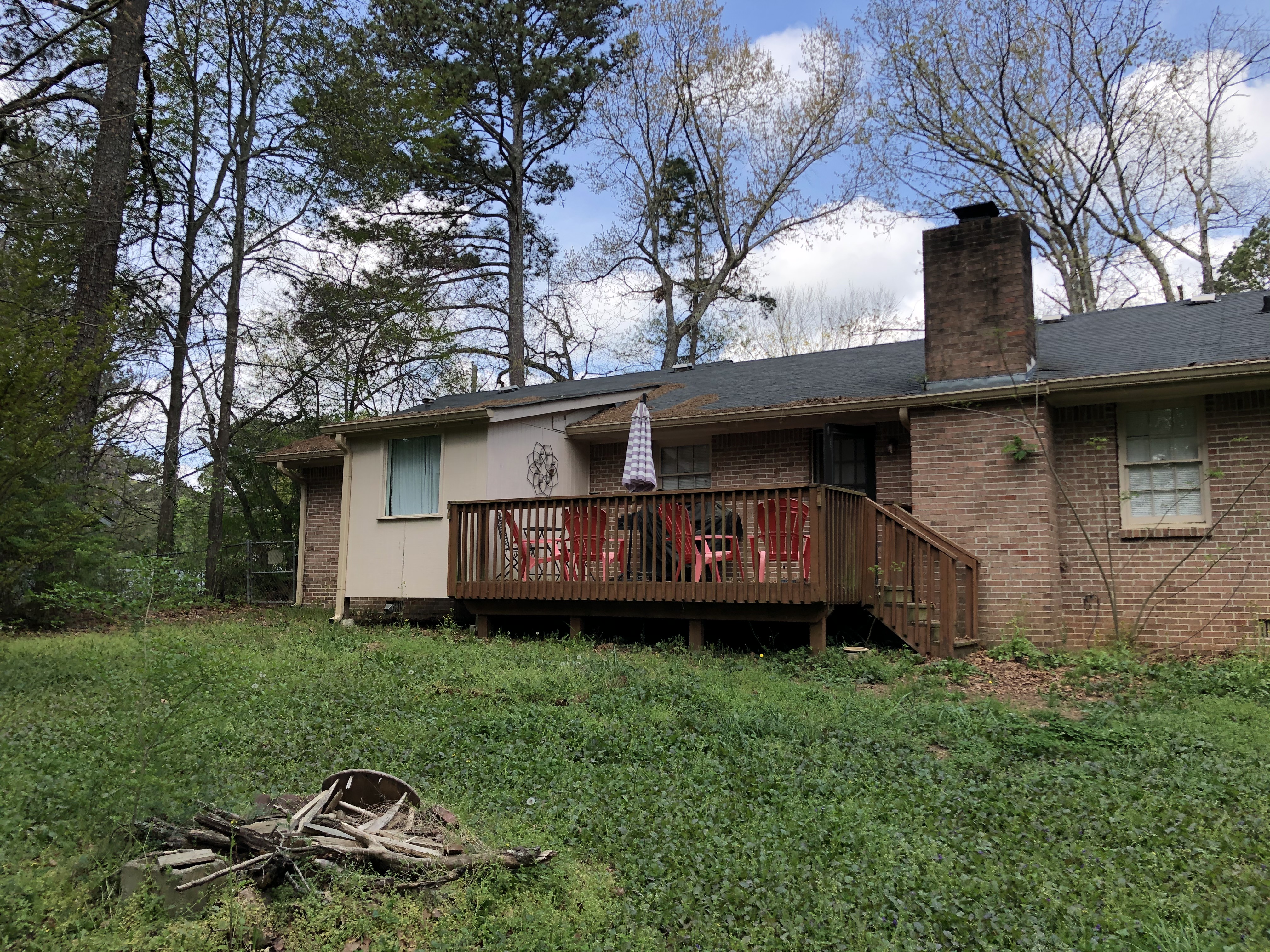 We buy houses as is in Lilburn GA. Back of brick house with rotten deck.