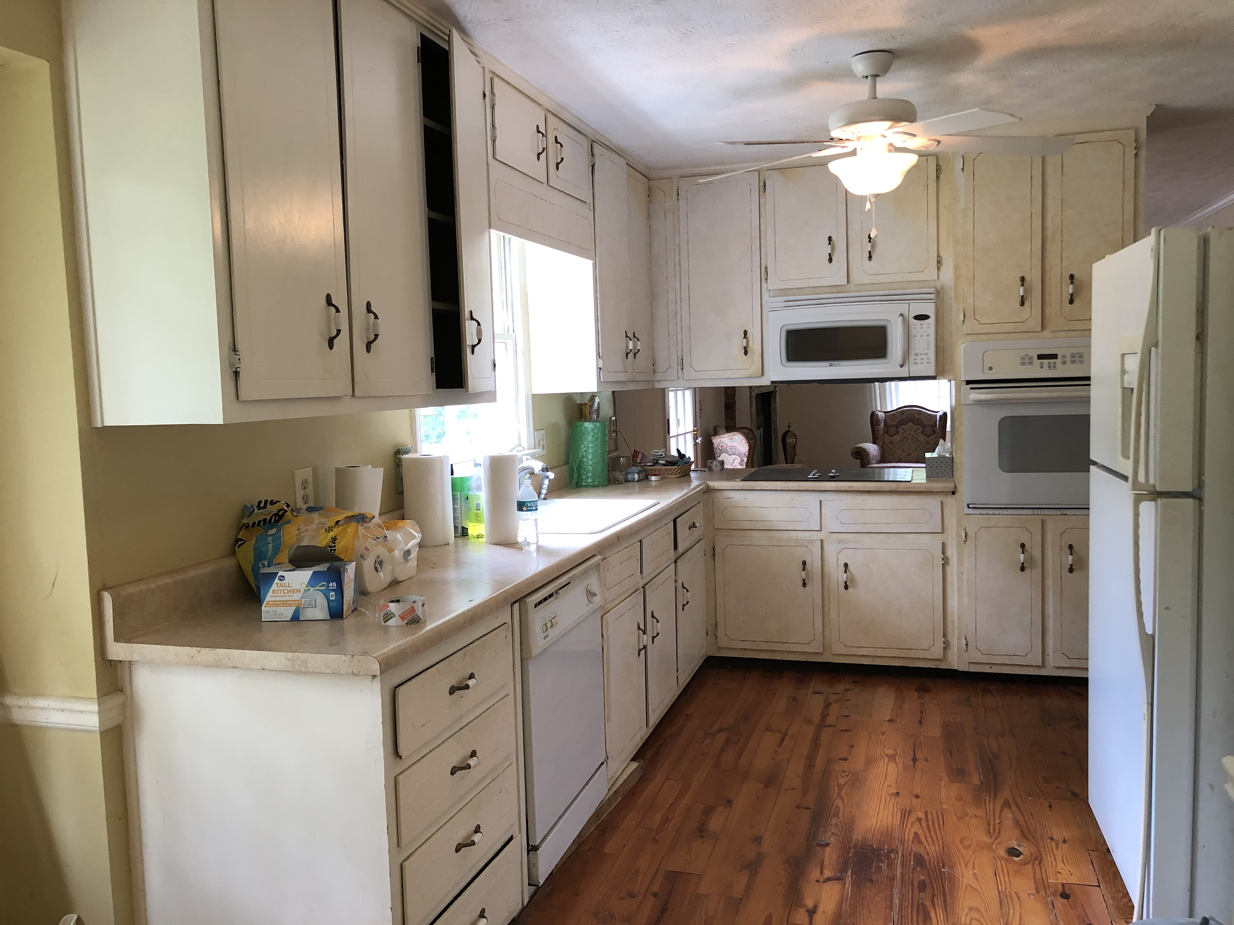We buy houses as is in Snellville GA. Yellowed greasy kitchen with outdated cabinets and appliances.