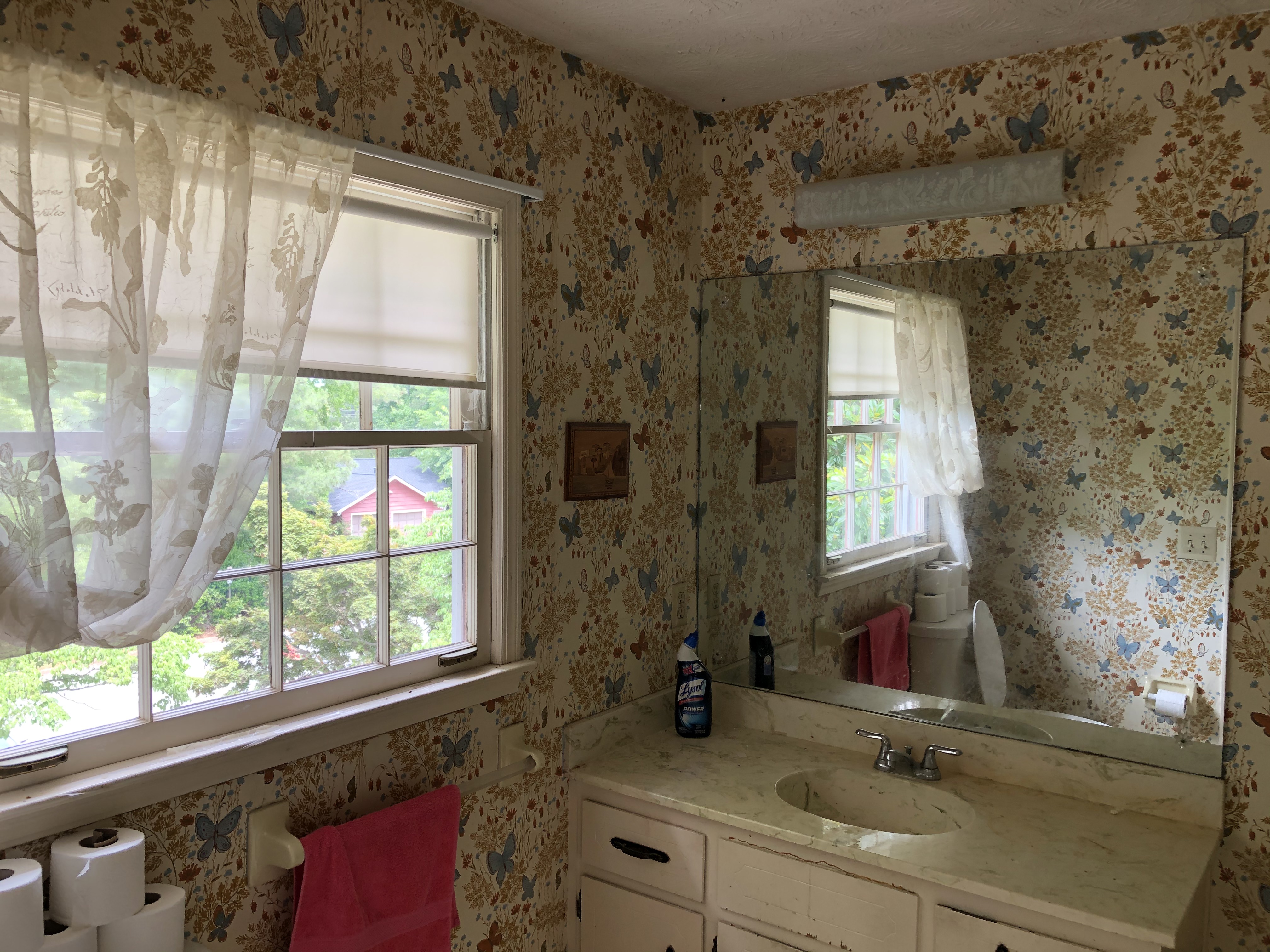 We buy houses fast in Snellville GA. Old bathroom covered in floral wallpaper.