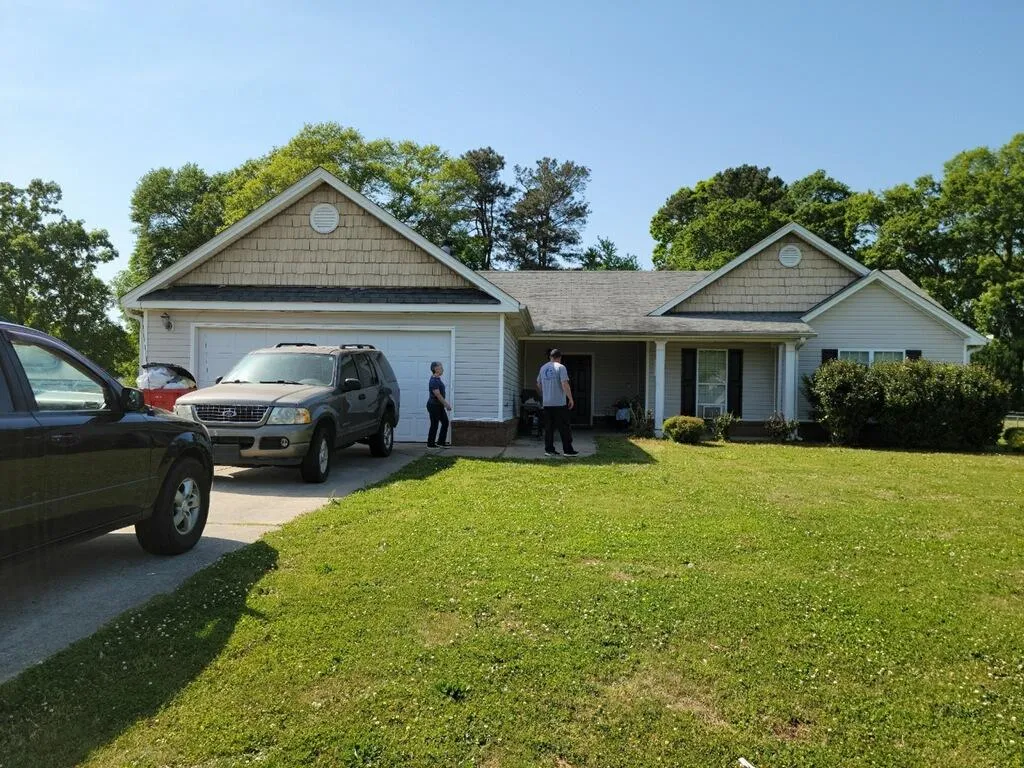 Sell my house fast in Snellville GA. Ranch house with lots of cars in driveway.
