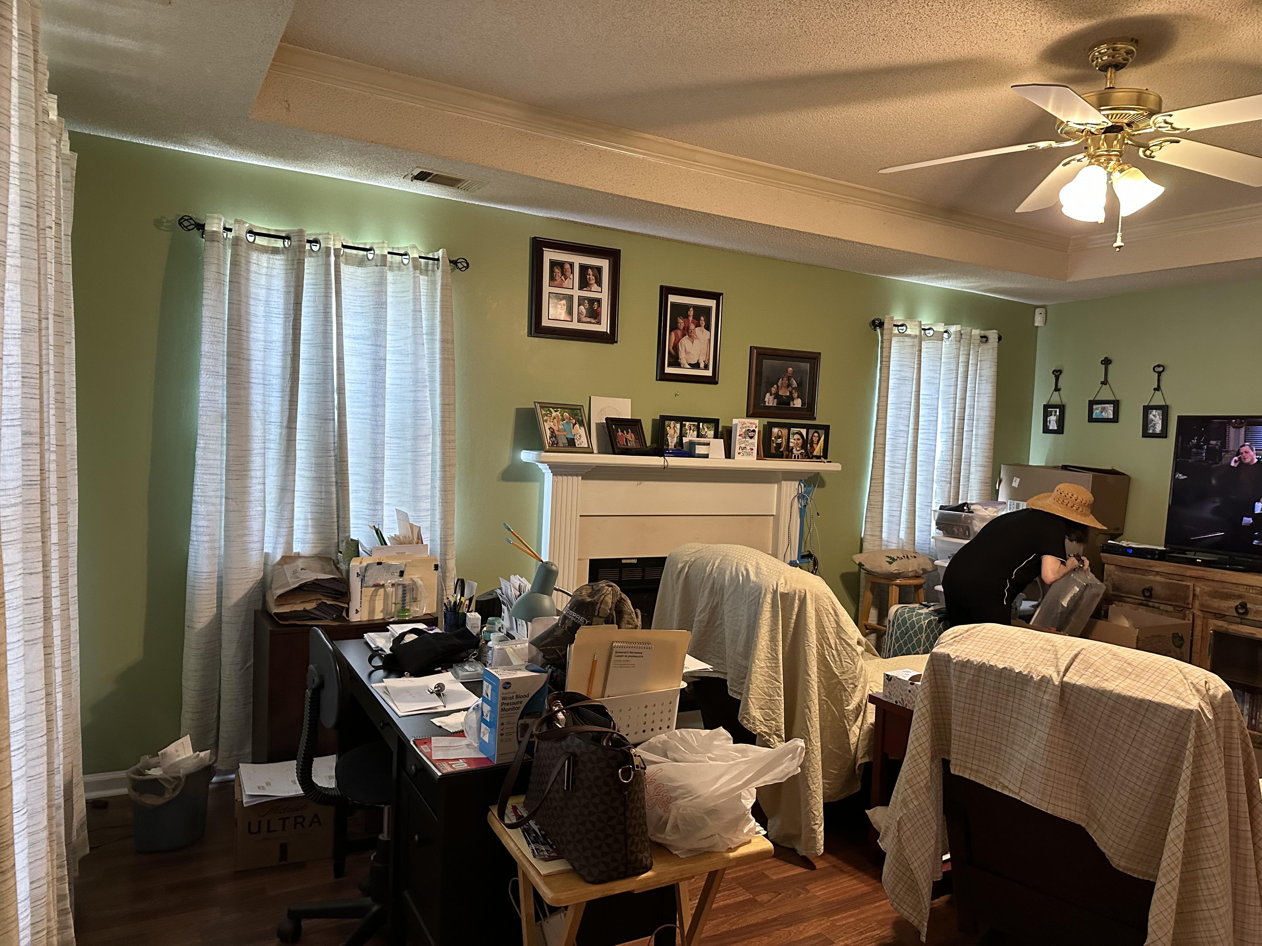 We buy foreclosures fast in as is condition. Cluttered living room in need of updates