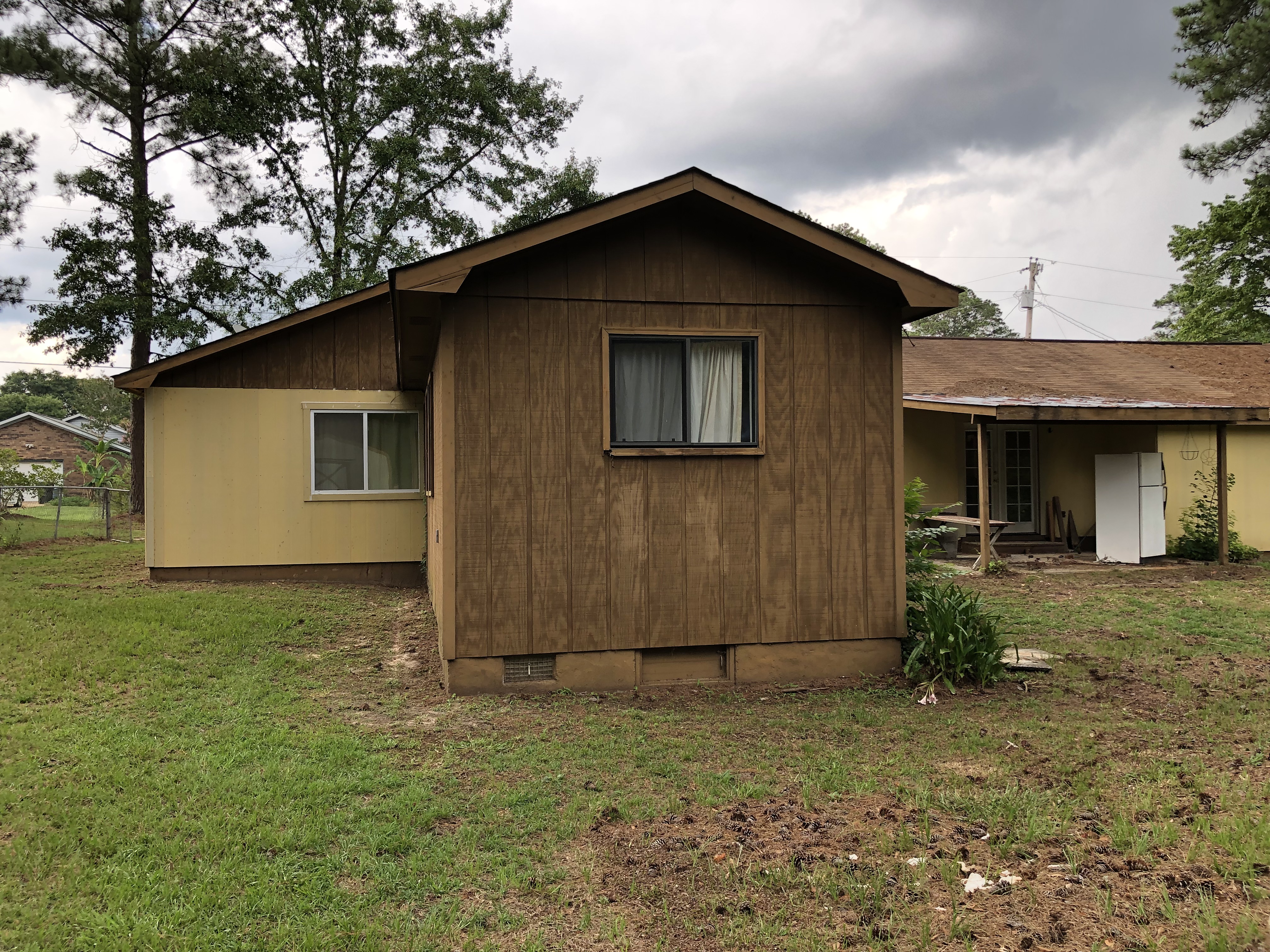 Sell a house in foreclosure before time runs out. Back of a house that needs siding work and paint.
