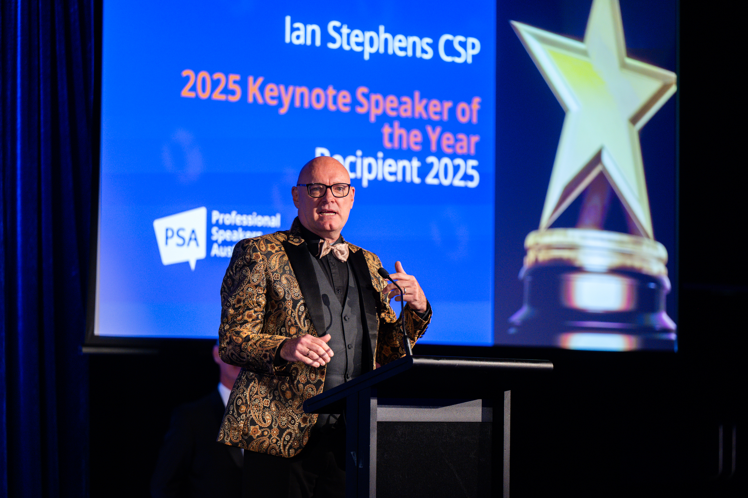 man in blue denim top standing under tree leaf