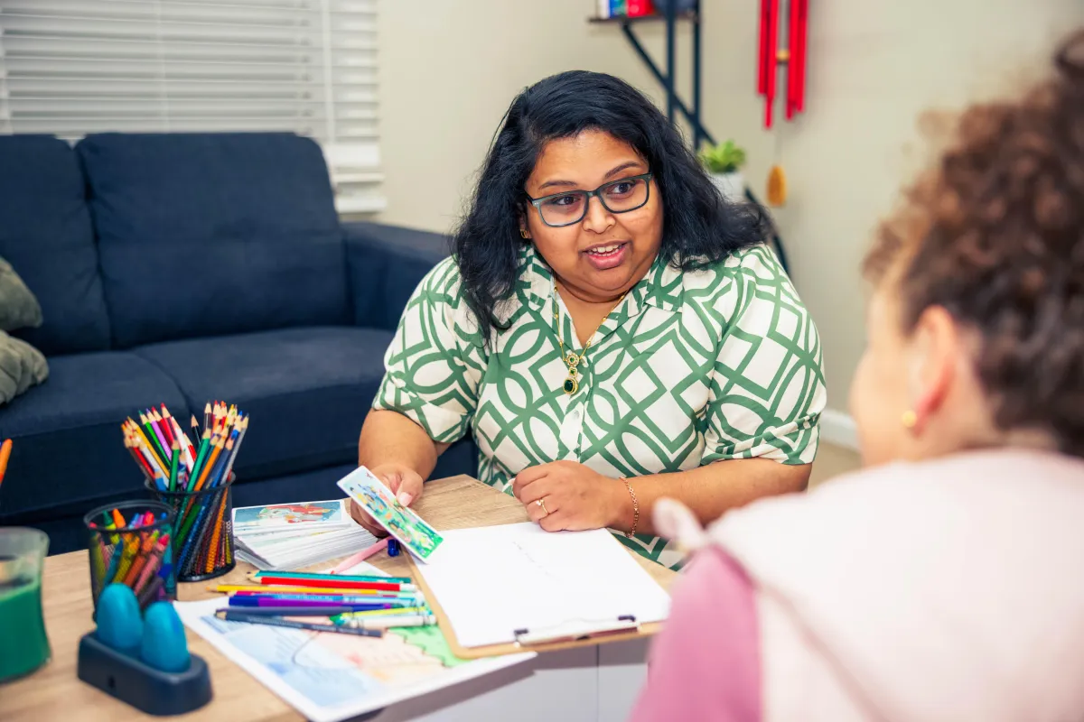 A woman walking along a sunlit forest path, symbolising the gentle journey of healing and coming home to oneself.