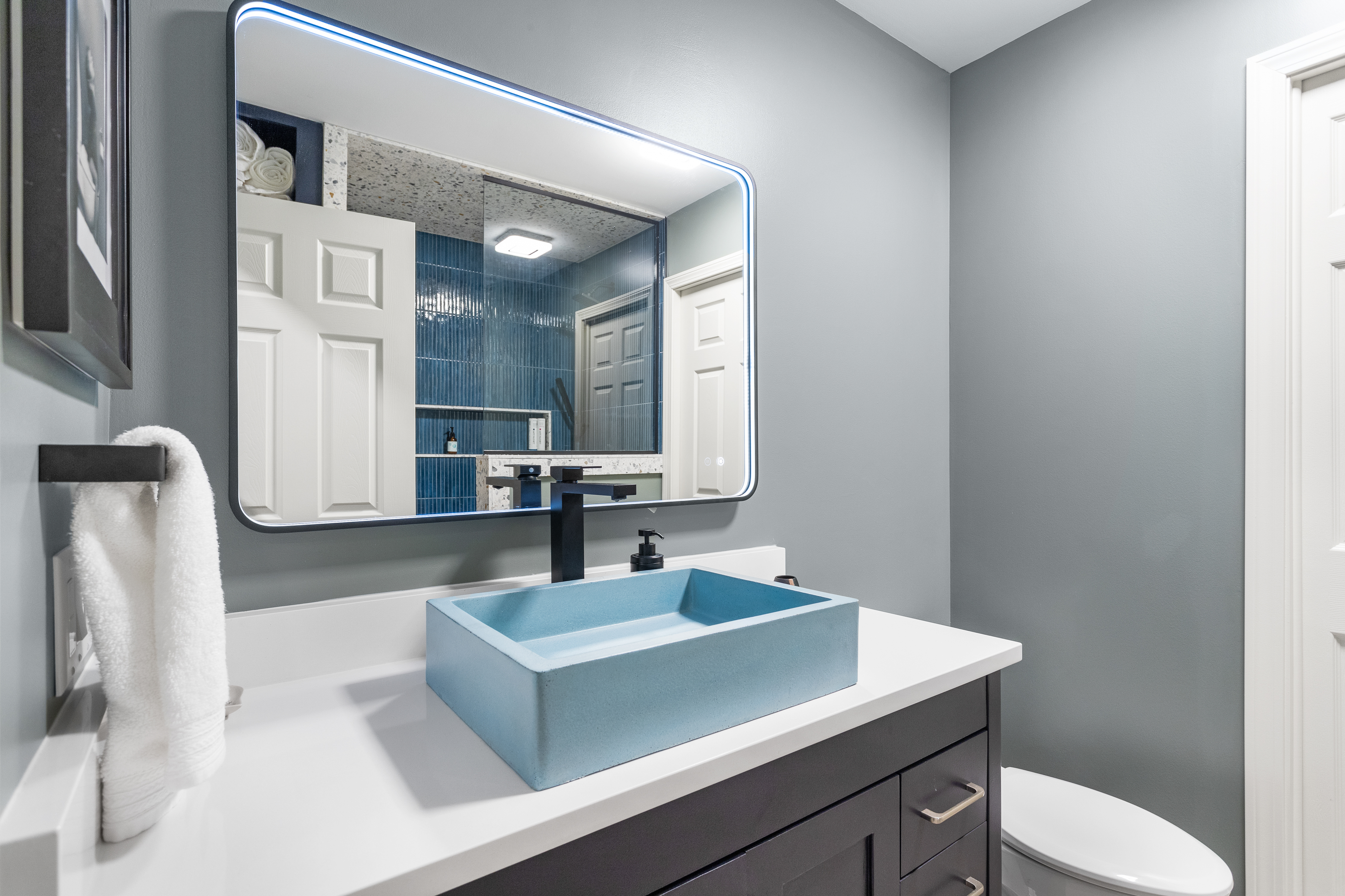 Full bathroom remodel with raised blue sink and dark cabinets completed by TPC Construction in Grand Rapids