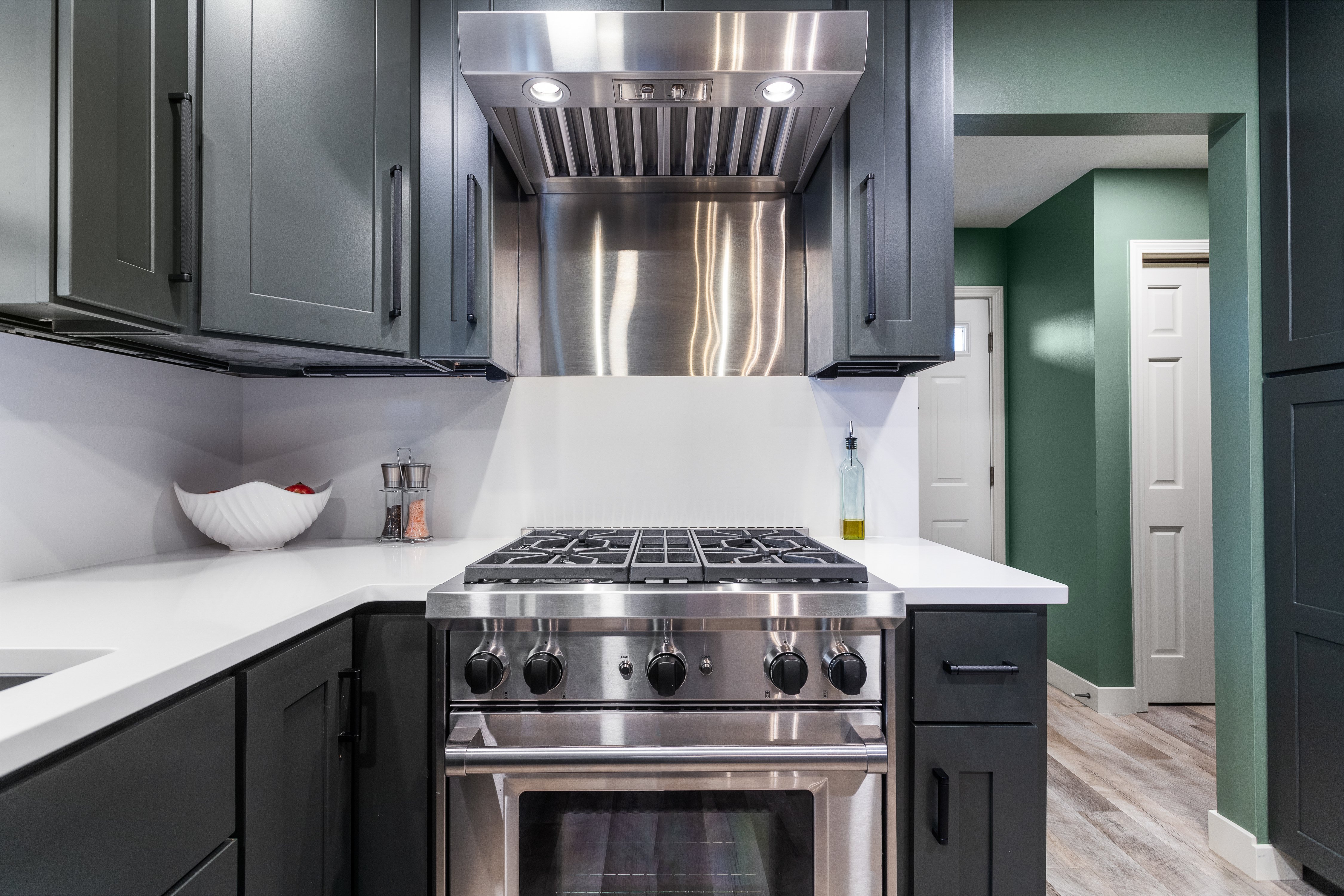 Kitchen remodel showing new gas range and vent fan completed by TPC Construction