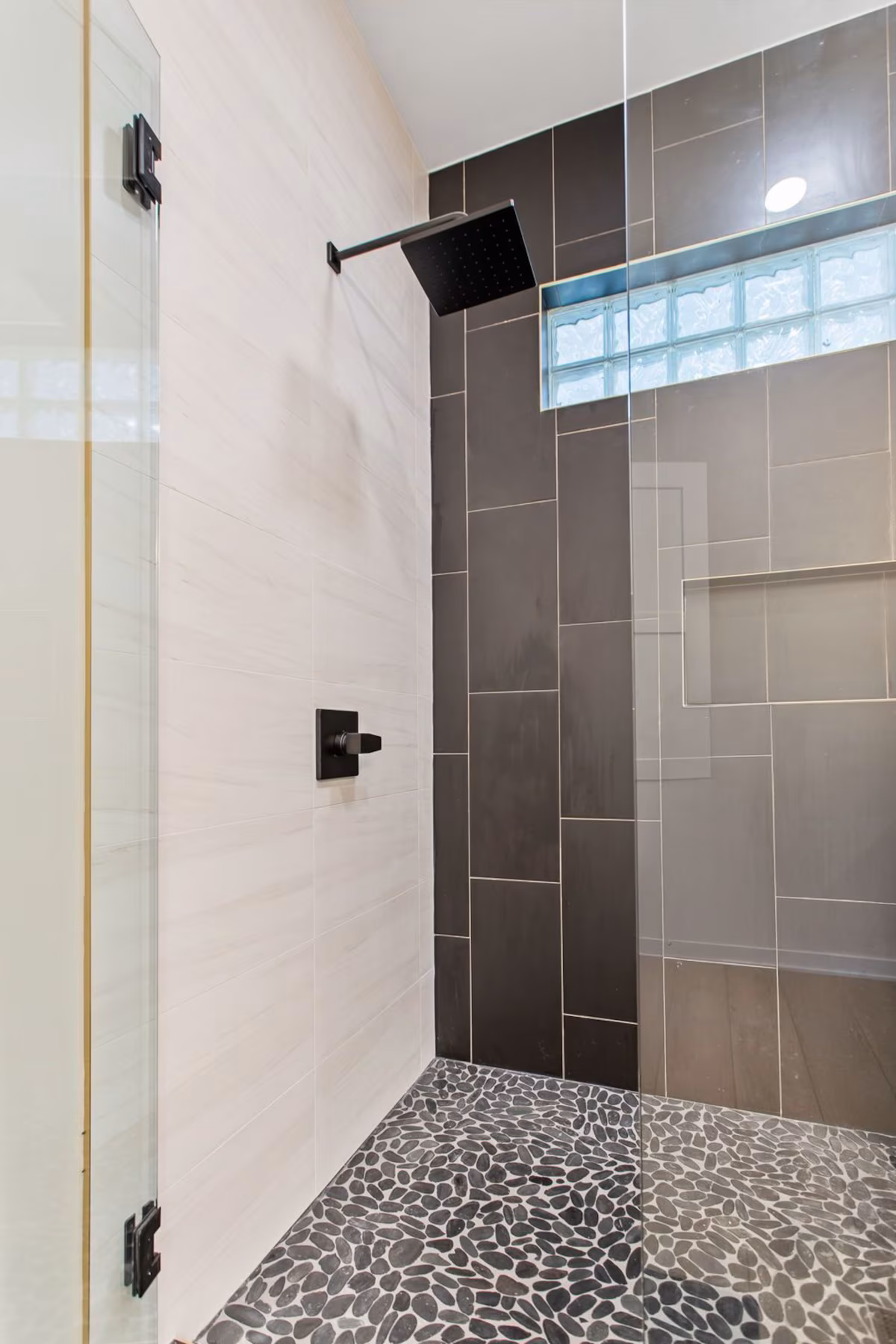 Rainfall showerhead in shower with tall glass doors