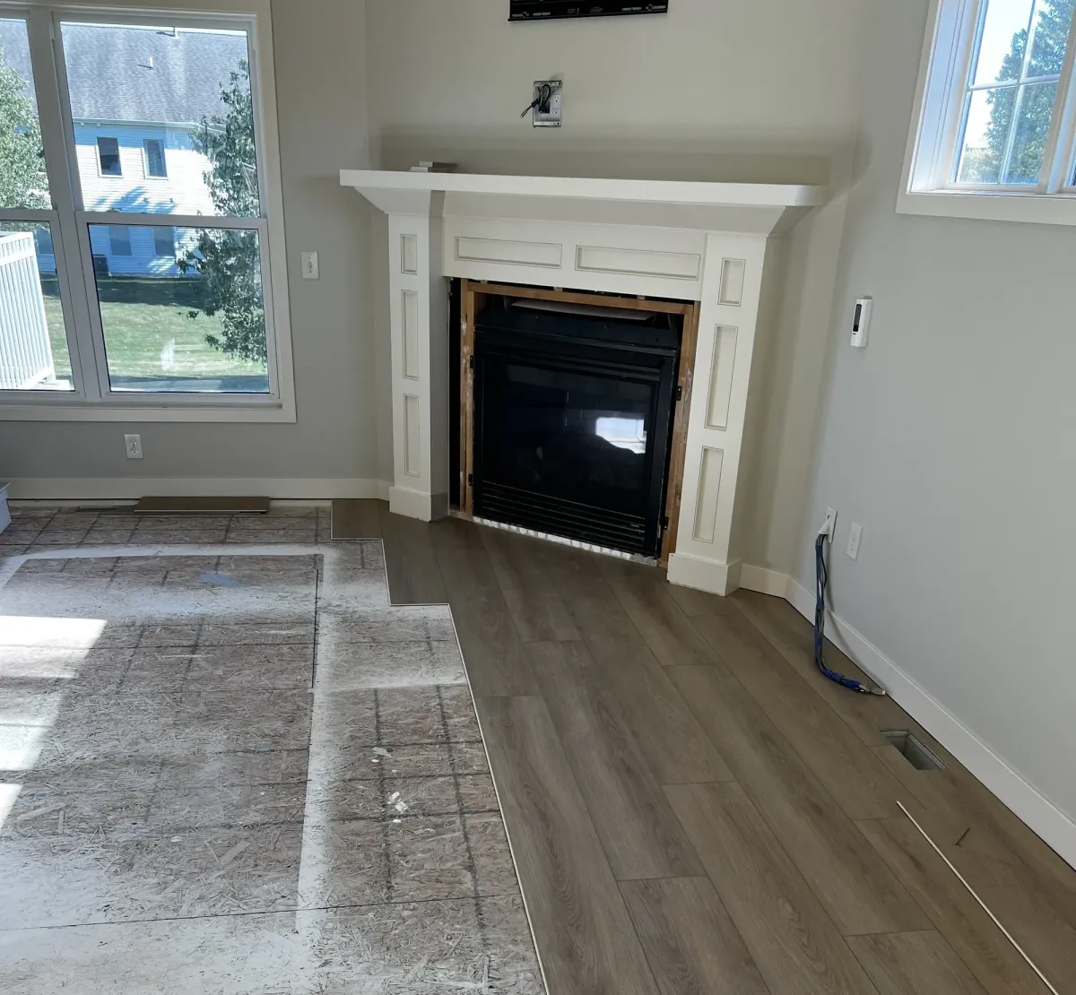 LVP flooring being installed in front of fireplace