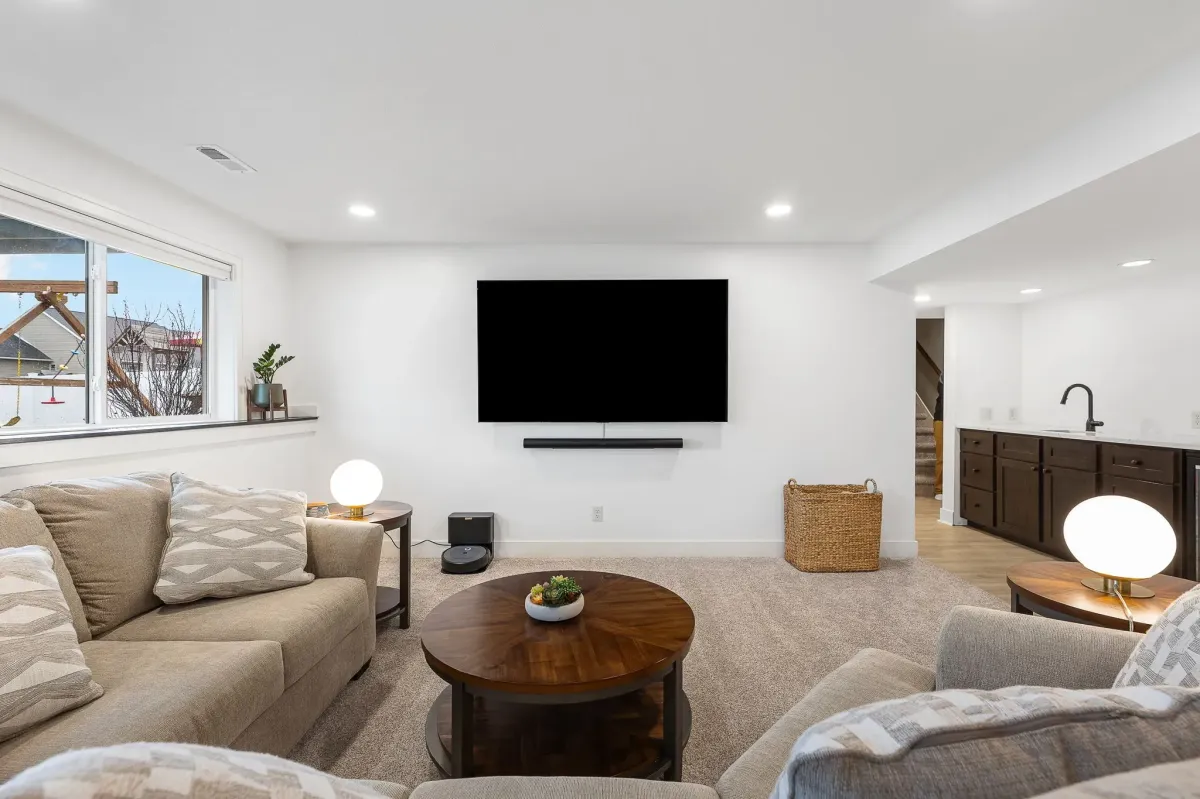 Basement remodel showing finished and furnished living area completed by TPC Construction in Byron Center, MI