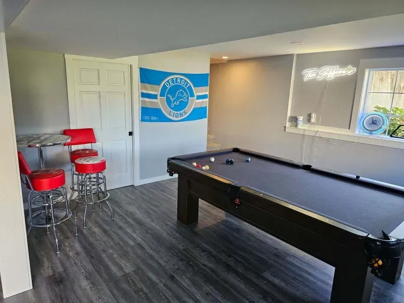 basement remodel with pool table and natural lighting