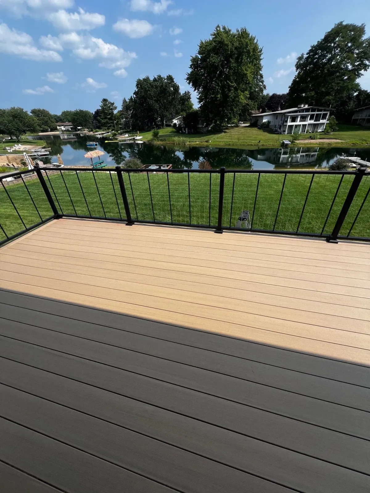 New deck installation in Grand Rapids with black rails overlooking pond