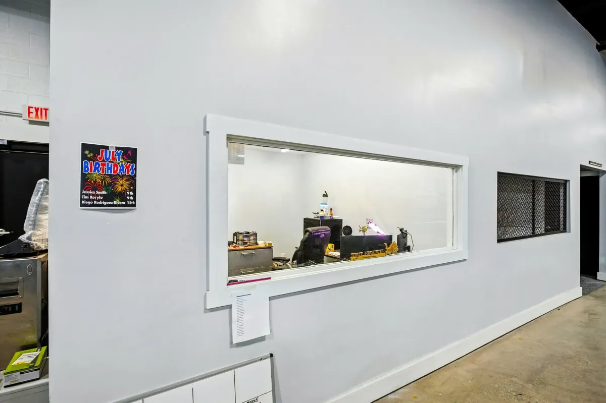 Remodeled office with window looking out into shop space.