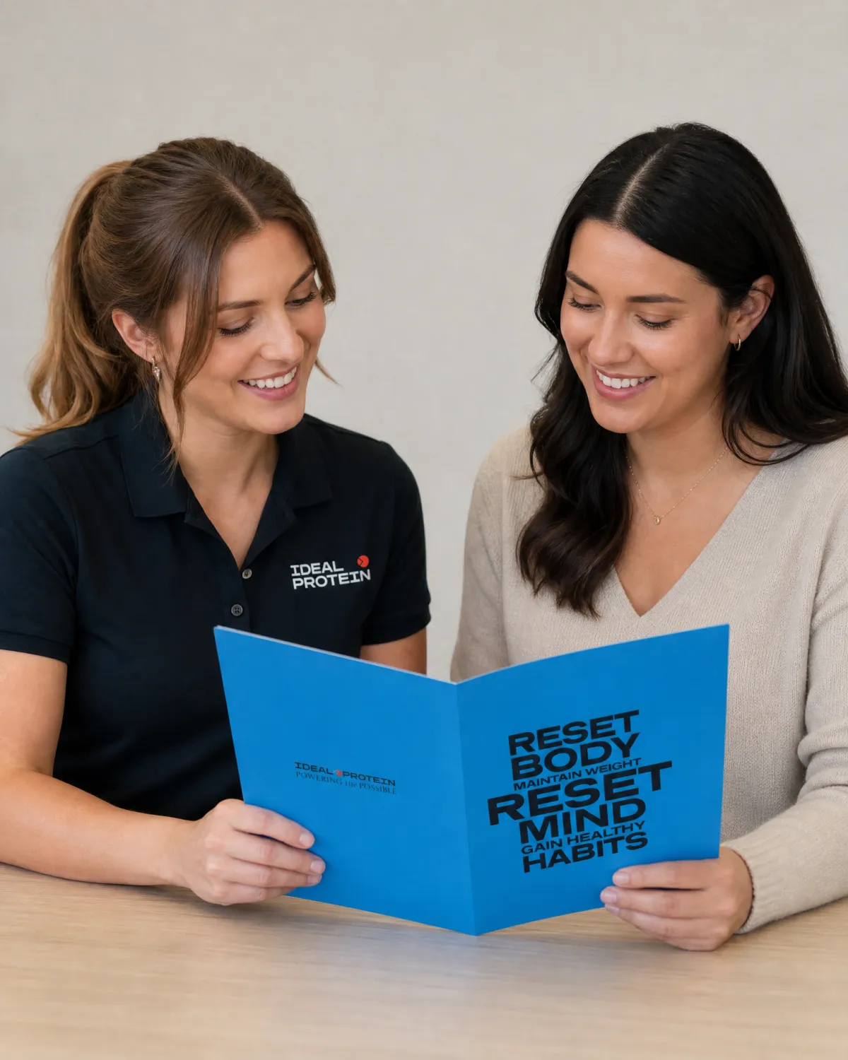 Certified Ideal Protein coach reviewing a maintenance nutrition plan with a client, representing the ongoing one-on-one coaching relationship that functions as a nutritional advisor throughout the Ideal Protein maintenance program