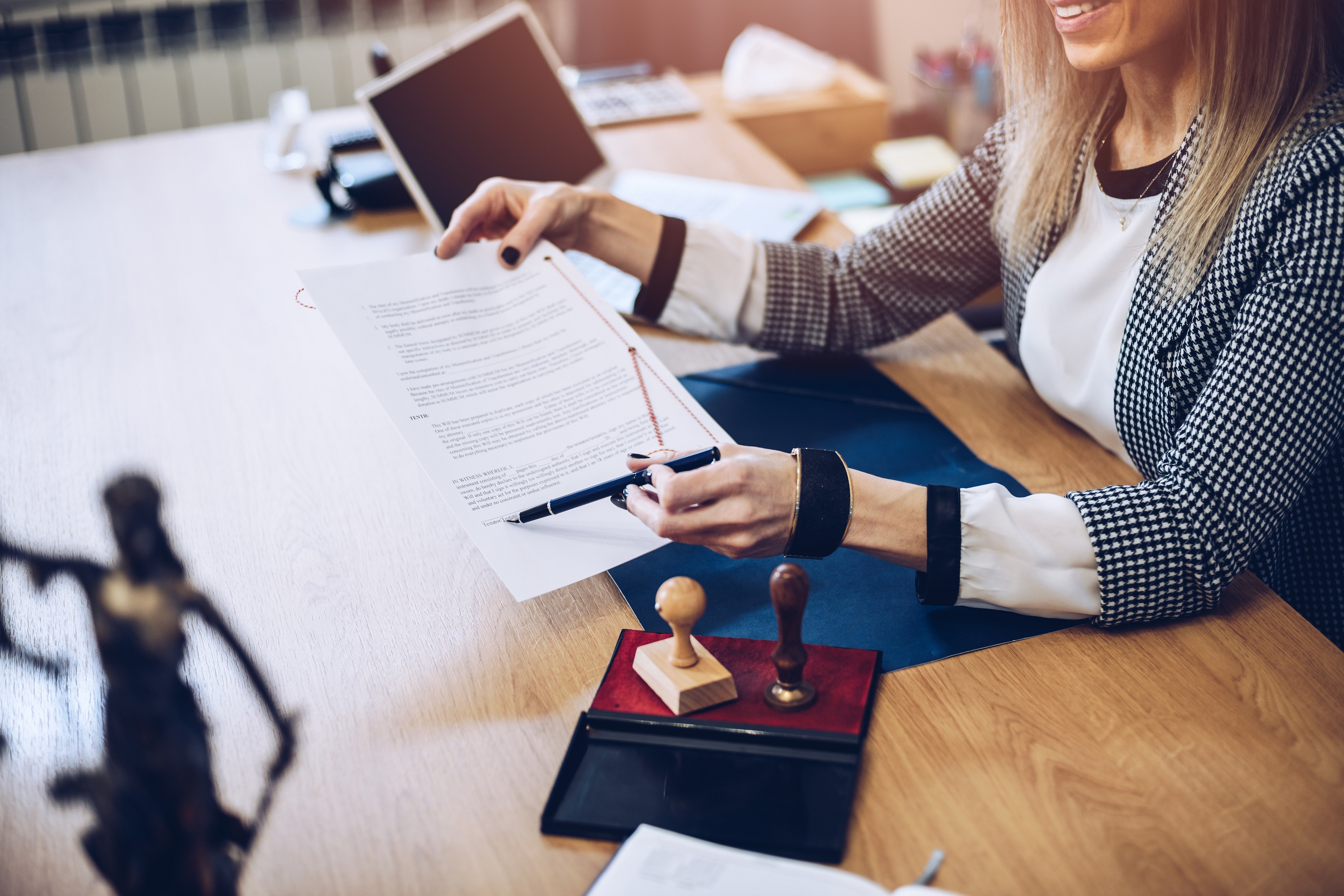 Client signing business documents at a notary's desk
