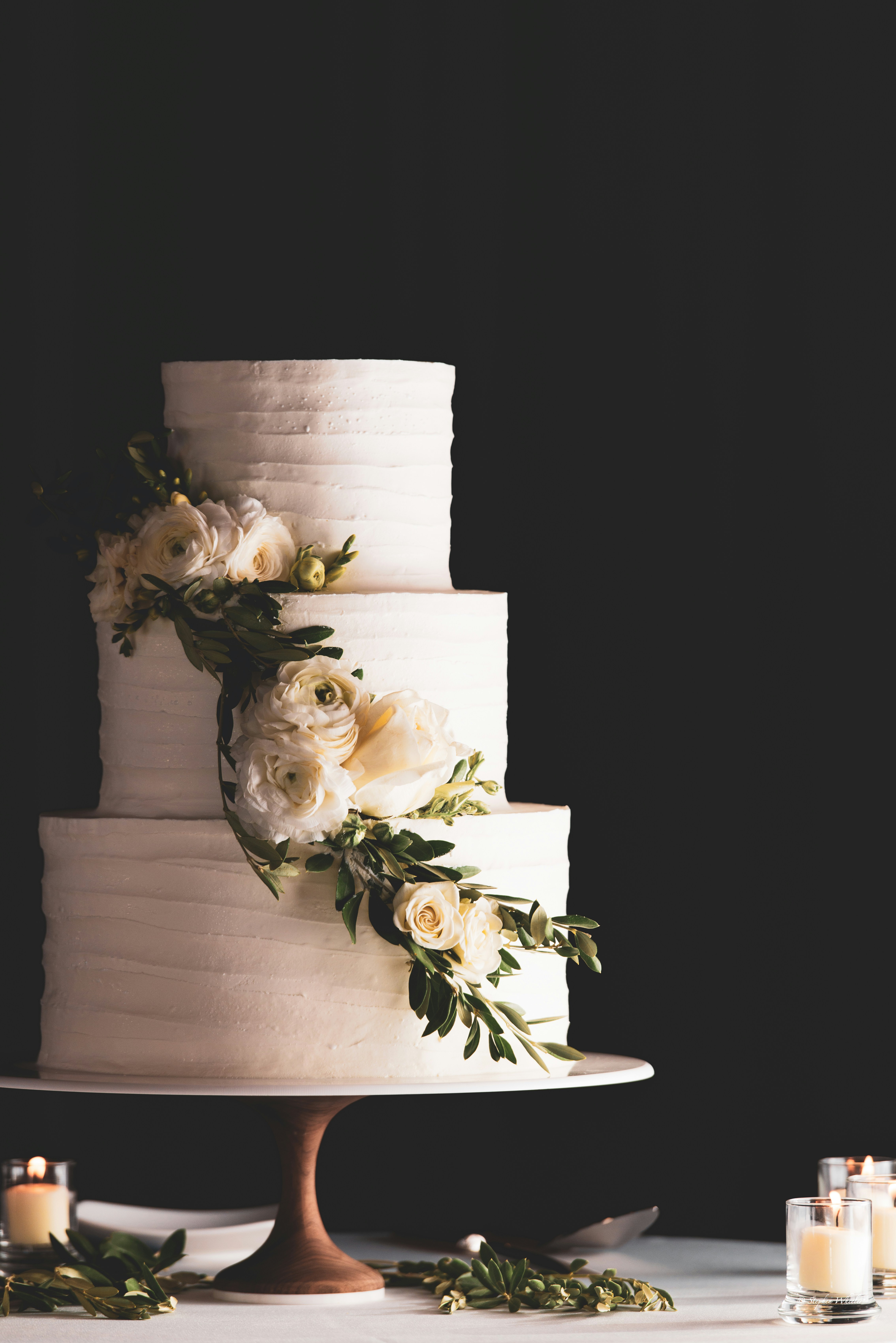 A three-tiered cake decorated with flowers and leaves.