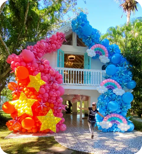 Outdoor balloon installation in pink, yellow, and blue with star accents for event