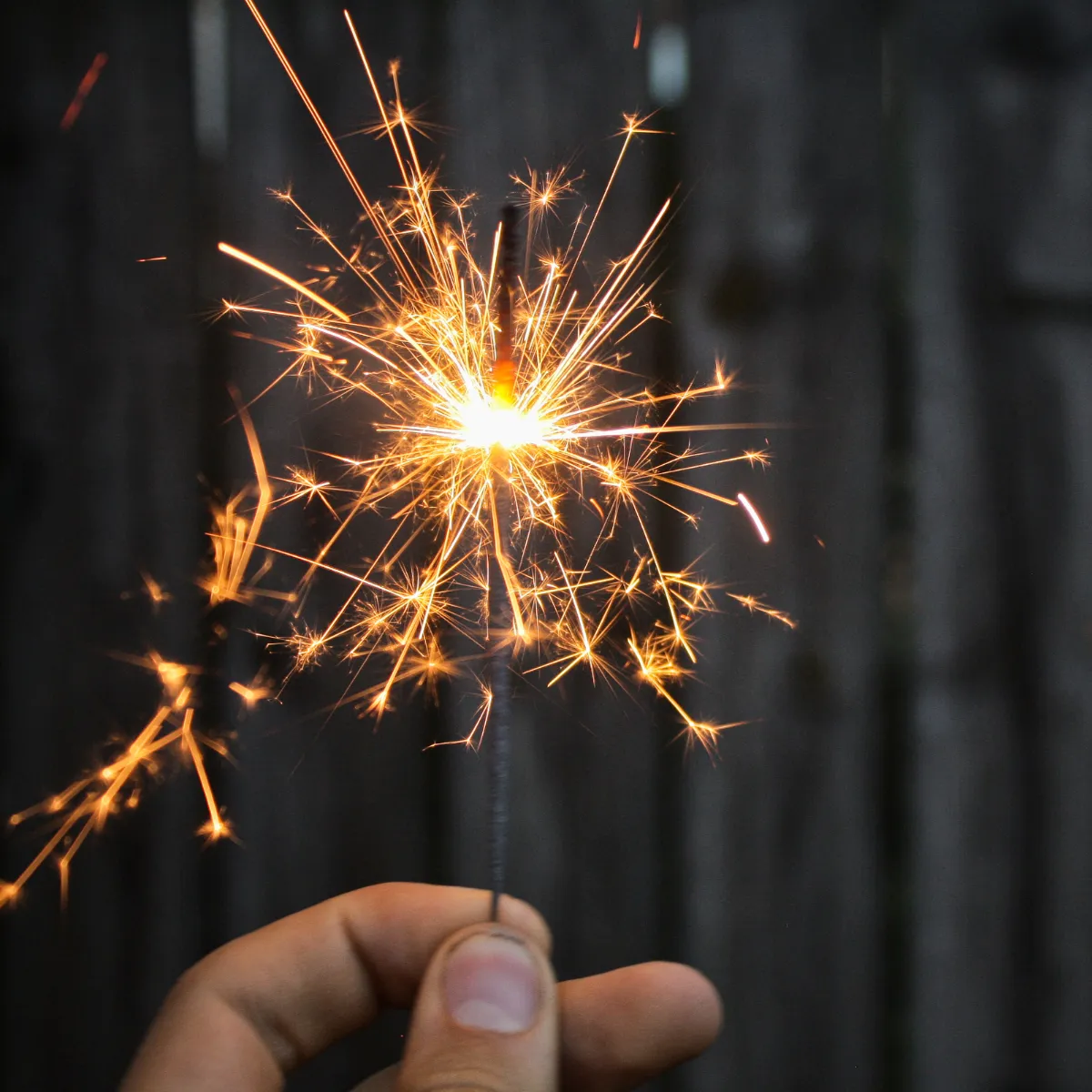 A vibrant, playful illustration of a diverse group of young adults tossing confetti and holding a large golden key labeled 'SPARK!' in a sunny park, with stylized cityscape in the background.