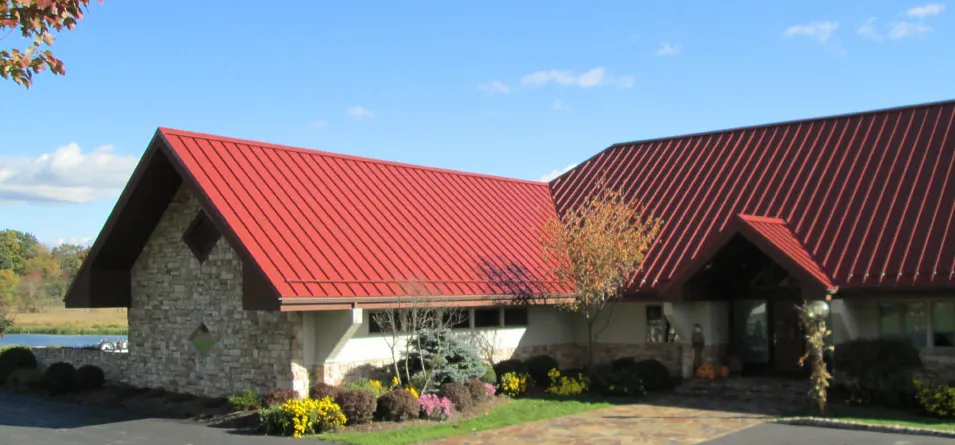 Metal roof with ridge vent and reflective coating under bright sun