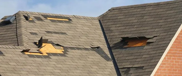 Colorado roofer repairing wind-damaged shingles